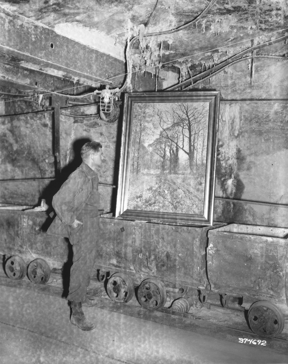 An American soldier discovers a framed painting that was looted by the Nazi regime in an underground vault.
