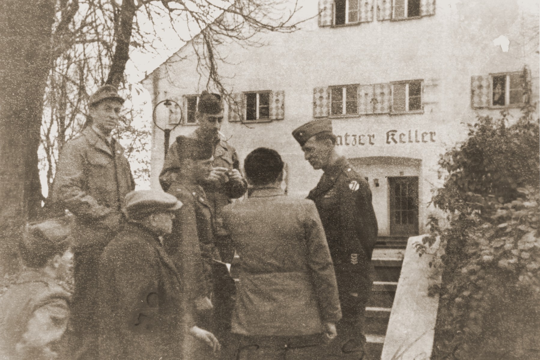 General Onslow Rolfe (top, right) and Major Irving Heymont (top, center) speak to Jewish DPs outside an administrative building in the Landsberg displaced persons camp.  

Also pictured is Dr. Samuel Gringauz (at the lower left).