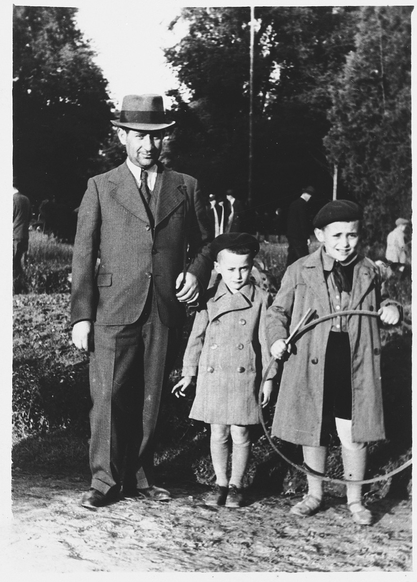 Isaac Friedberg poses outside with his two sons, Maurice (right) an Shimon (center).
