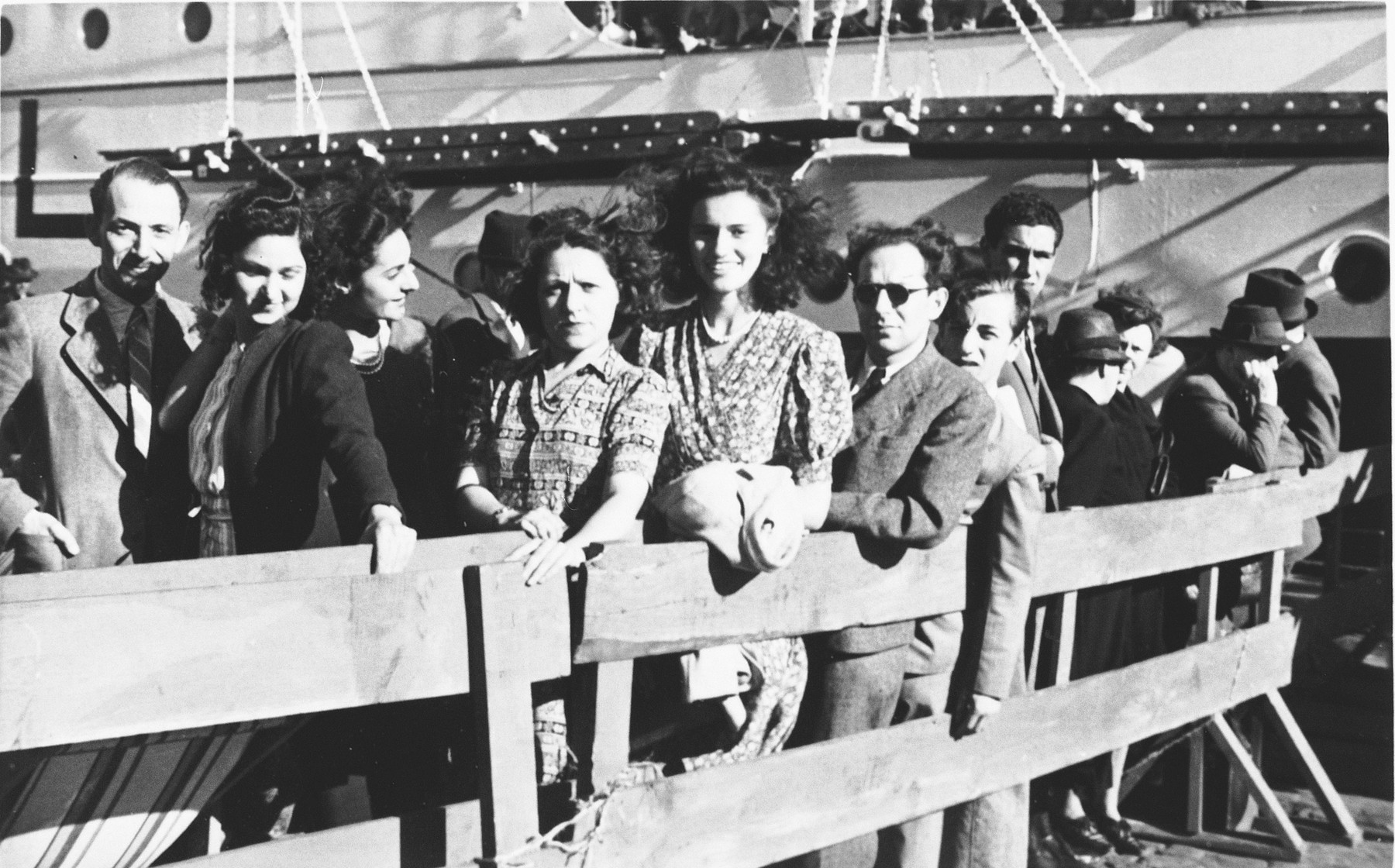 A group of Jewish refugees wait behind a wooden fence in the port of Lisbon before boarding the SS Mouzinho.