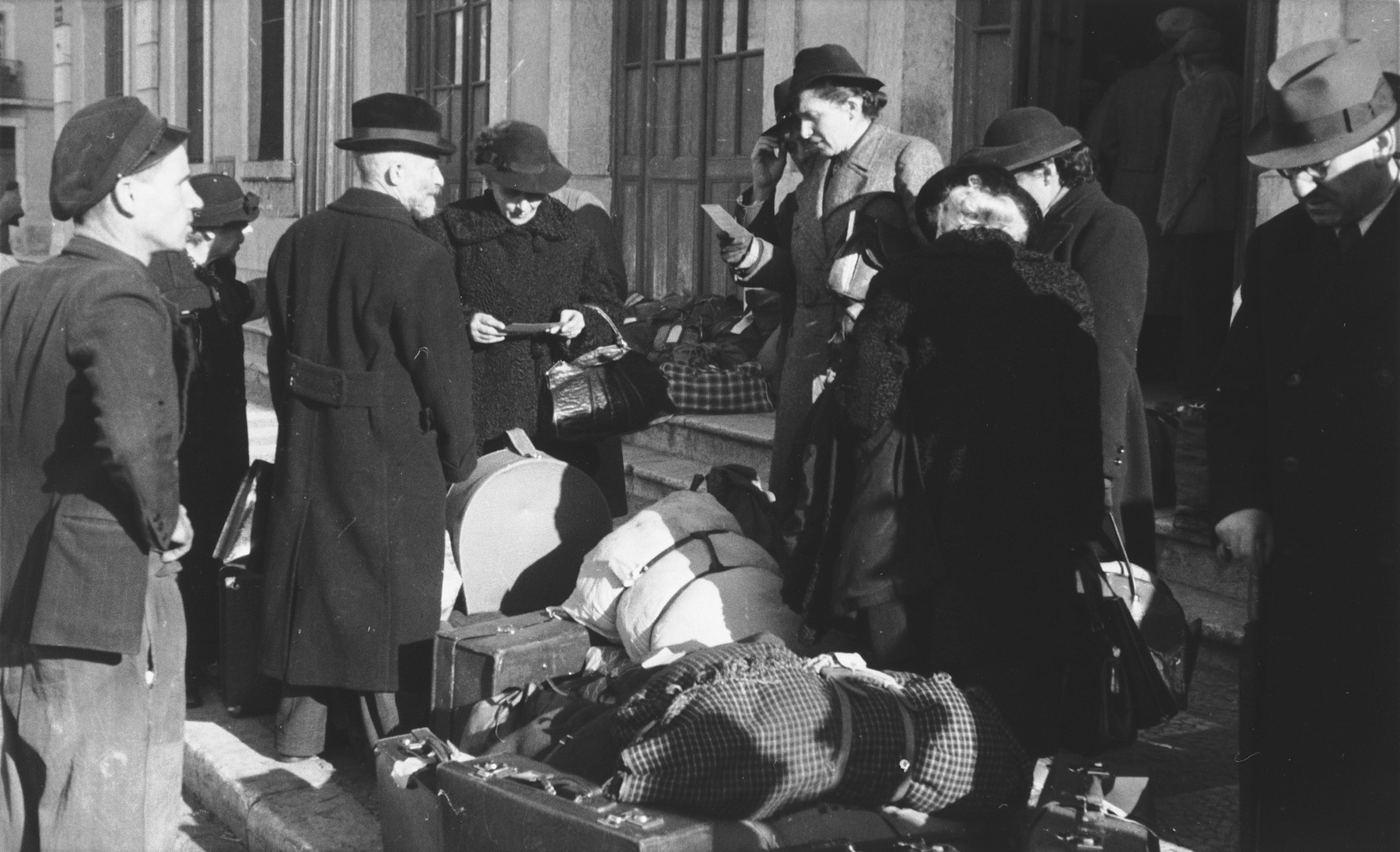 A group of Jewish refugees who have just arrived in Lisbon wait with their luggage in front of the St. Appolonia train station.