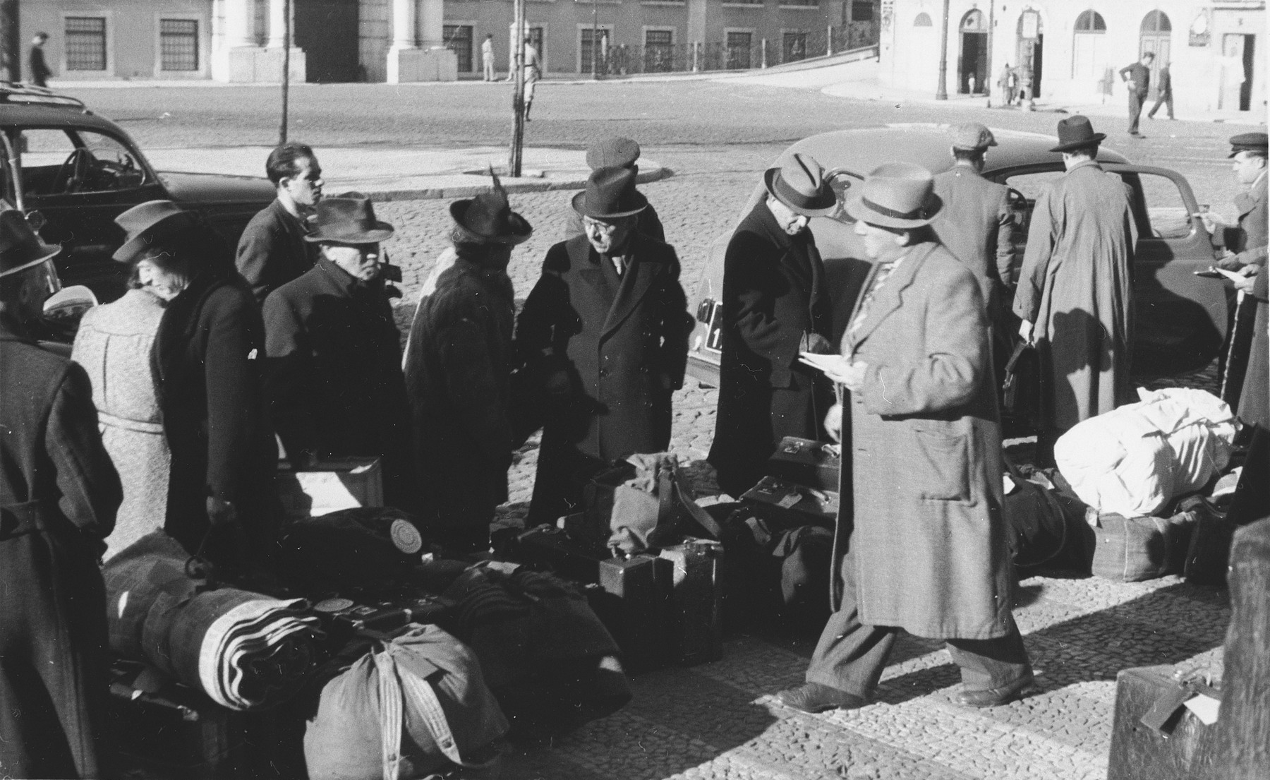 A group of Jewish refugees who have just arrived in Lisbon wait with their luggage in front of the St. Appolonia train station.