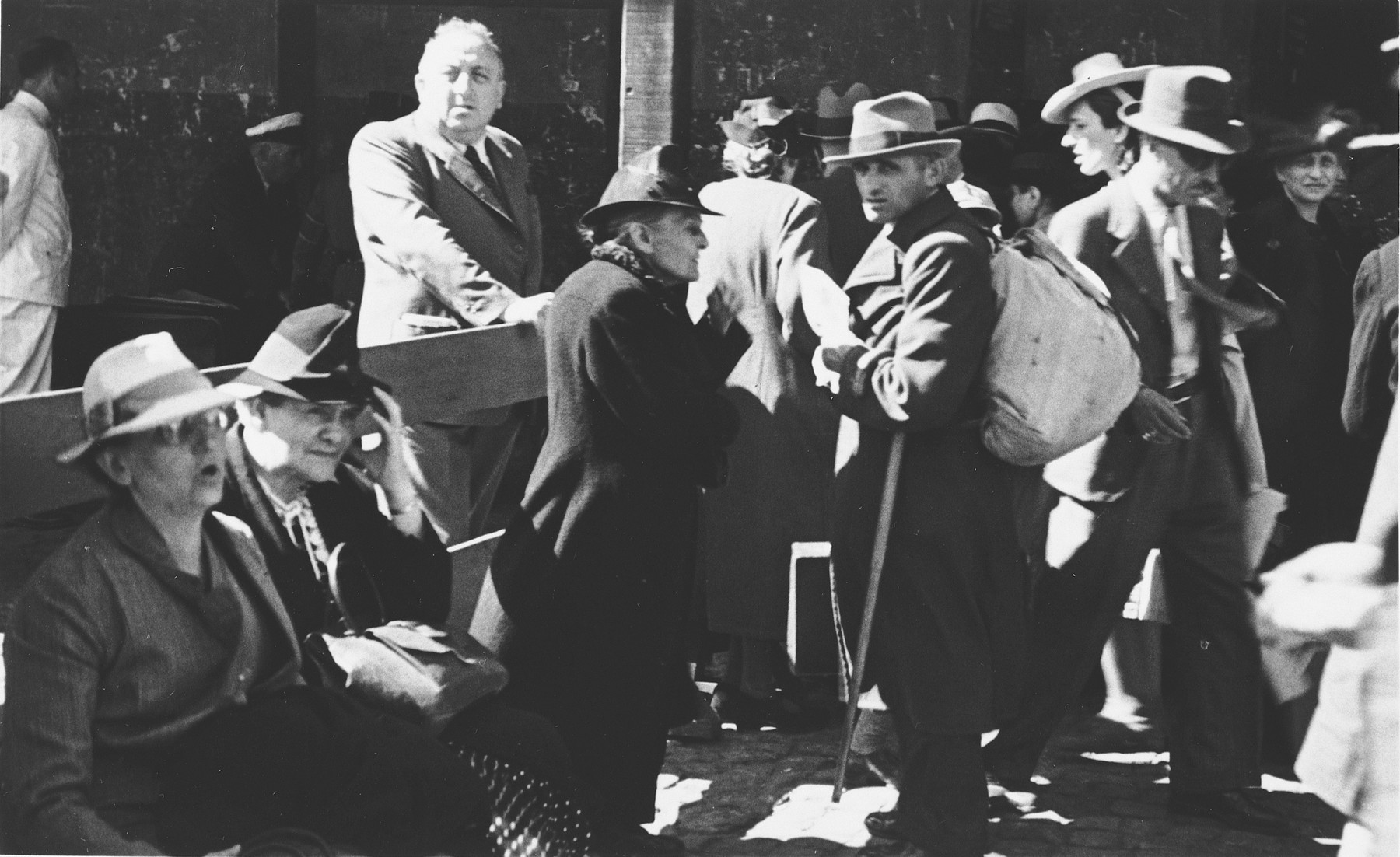 Albert Nussbaum, Director of Transmigration for the American Joint Distribution Committee, observes the scene at the port of Lisbon where Jewish refugees wait to board the SS Mouzinho.
