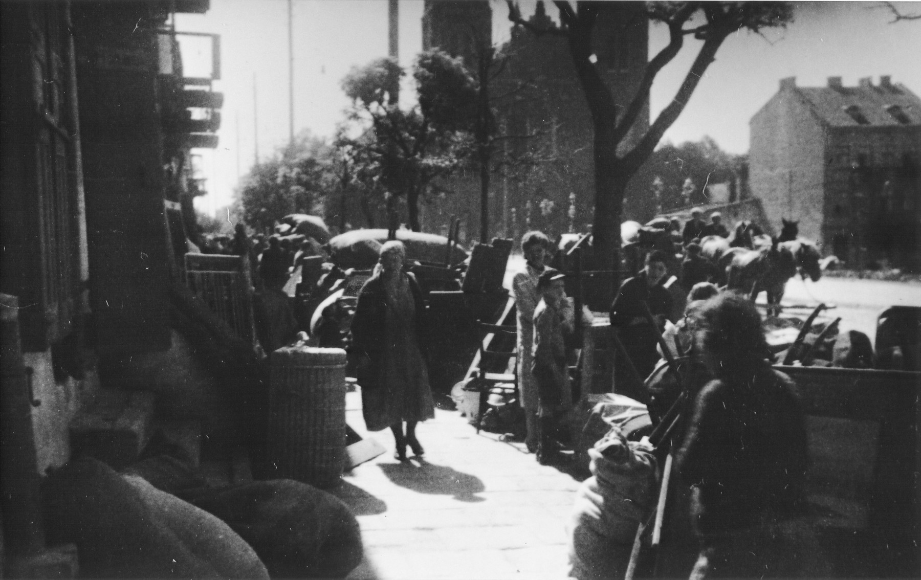 Piles of furniture and household belongings of Jews who are being transferred to the ghetto cover the pavement of a street in Kutno.

The original German caption reads: "Evacuation of Kutno. Jews out!"