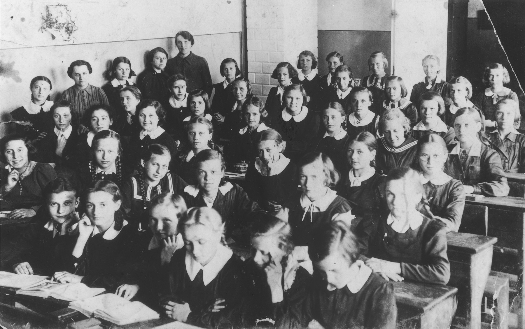 Seventh grade students and teachers pose in their classroom at the public school on Narutowicza Street in Dabrowa Gornicza.  

Among those pictured are Pola Rozen; Frania Magierkiewicz; Hanka Lewkowicz; Zosia Putersznyt, Sala Szmeker; and the teacher, Mrs. Kaufiszer.