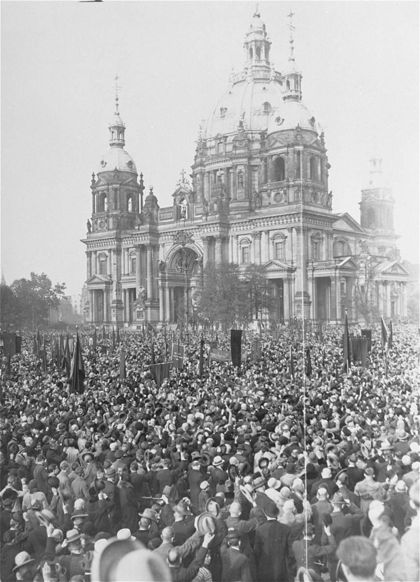 Supporters of the Socialist Party of Germany (SPD) cheer as M. Loebe, the former president of the Reichstag, delivers a speech in the Lustgarten in front of the Berlin Cathedral, condemning Adolf Hitler and the Nazi Party.
