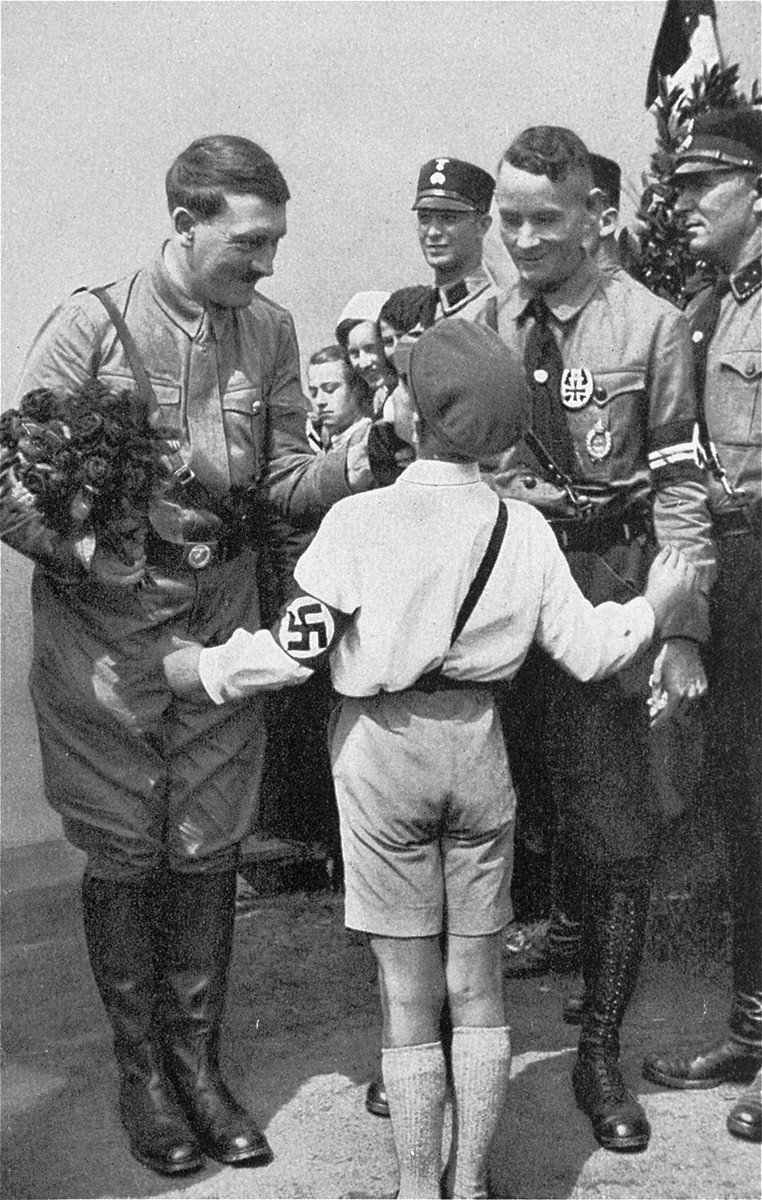 Hitler accepts a bouquet from a young admirer during the presidential elections of 1932.

The man pictured second from the right has been identified as Friedrich Karl Florian, Gauleiter of Duesseldorf.