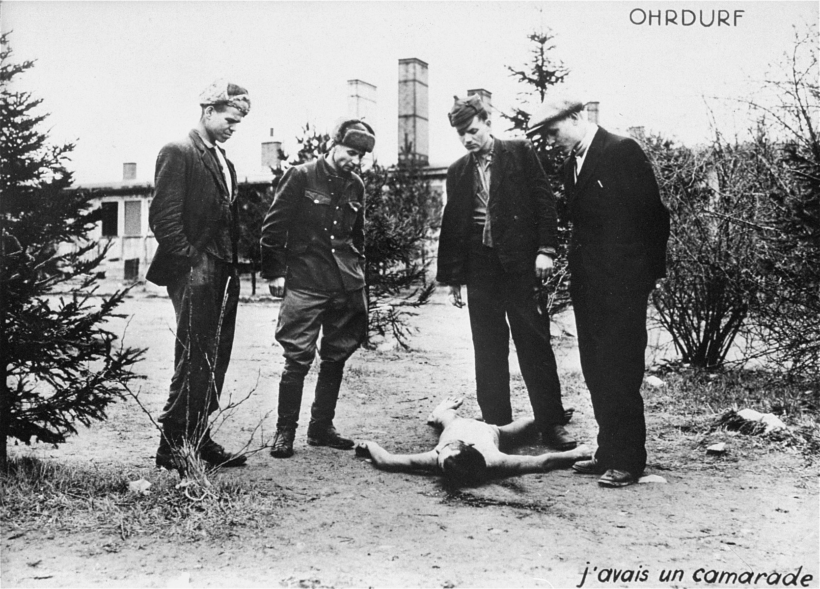 Survivors in Ohrdruf beside the corpse of one of their friends.