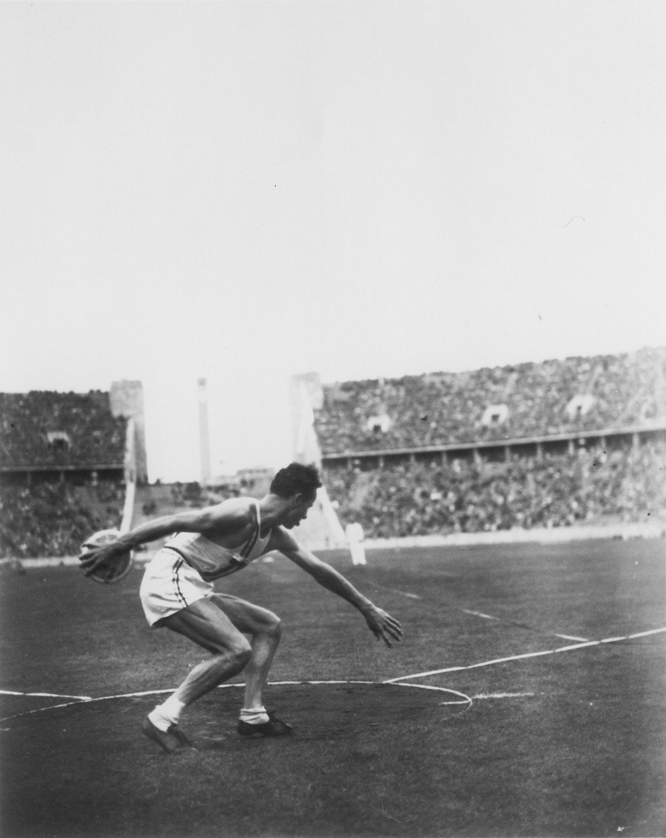 An American man competes in the discus competition at the 11th Summer Olympic Games.