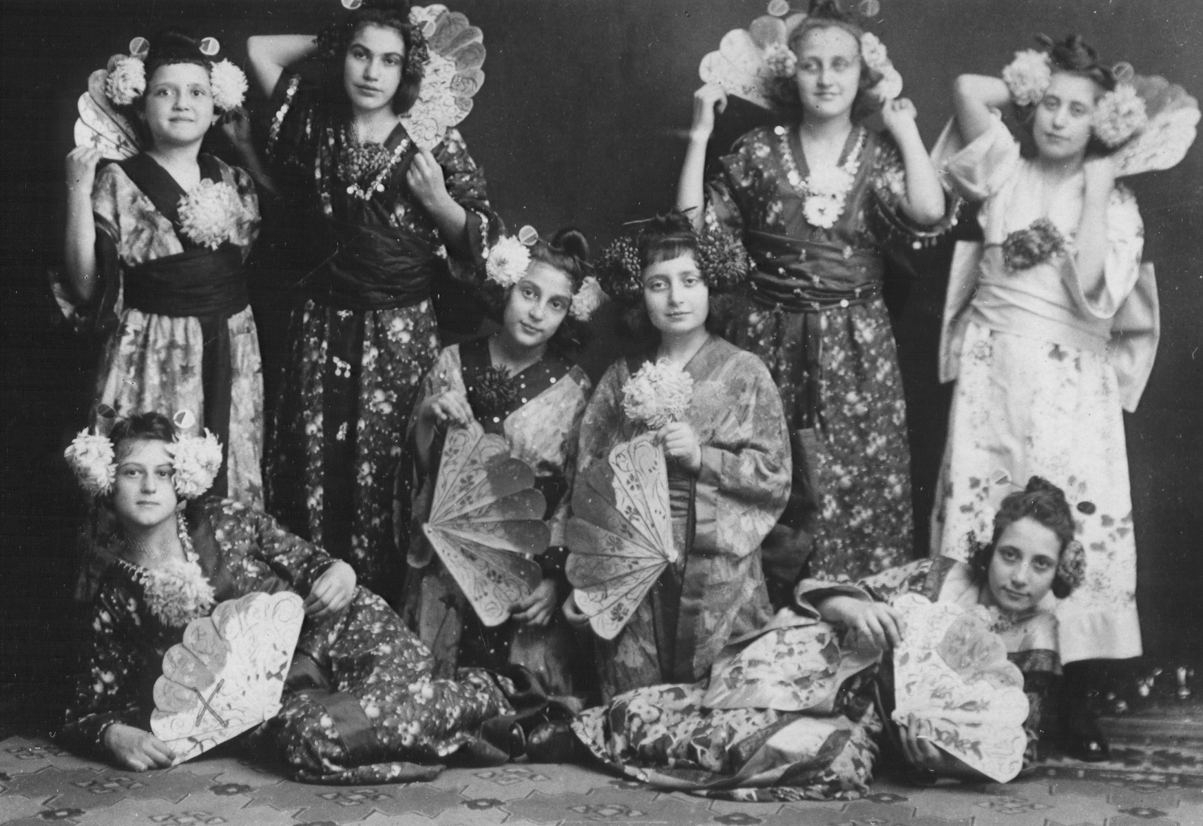 School girls pose wearing Japanese costumes and holding decorative fans.

Lili Koenig is on the bottom left.