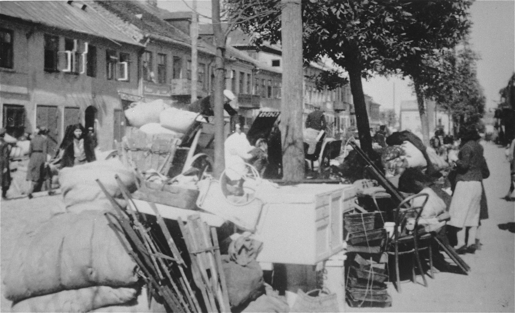 Piles of furniture and household belongings of Jews who are being transferred to the ghetto cover the pavement of a street in Kutno.

The original German caption reads: "Evacuation of Kutno. Jews out!"