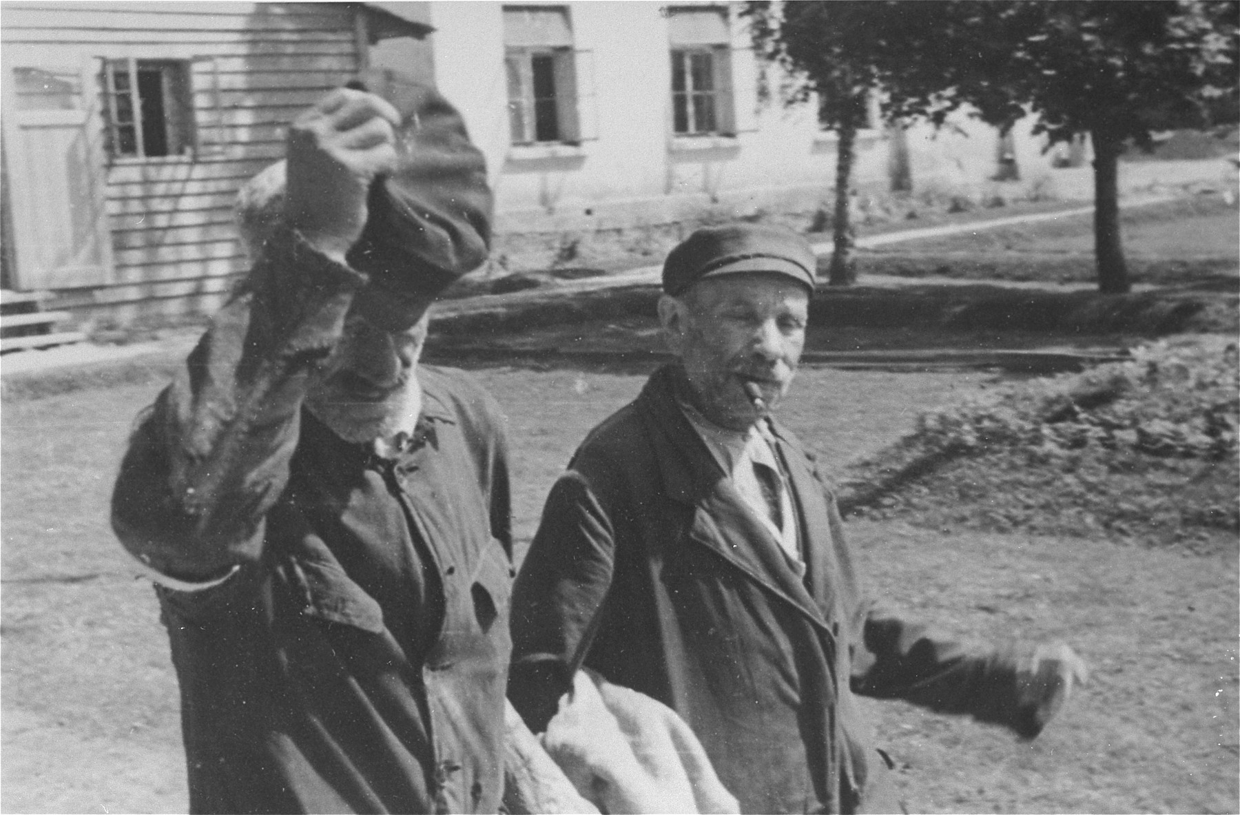 An elderly Jewish man doffs his hat as he walks outside with a companion in Konskowola.