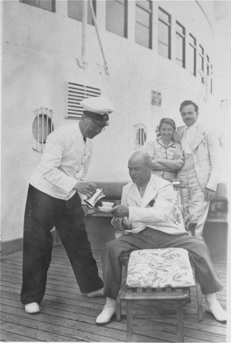 Steward serves coffee to Julius Hermanns on the deck of the MS St.  Louis.   

From a photo album belonging to St. Louis passenger Moritz Schoenberger.