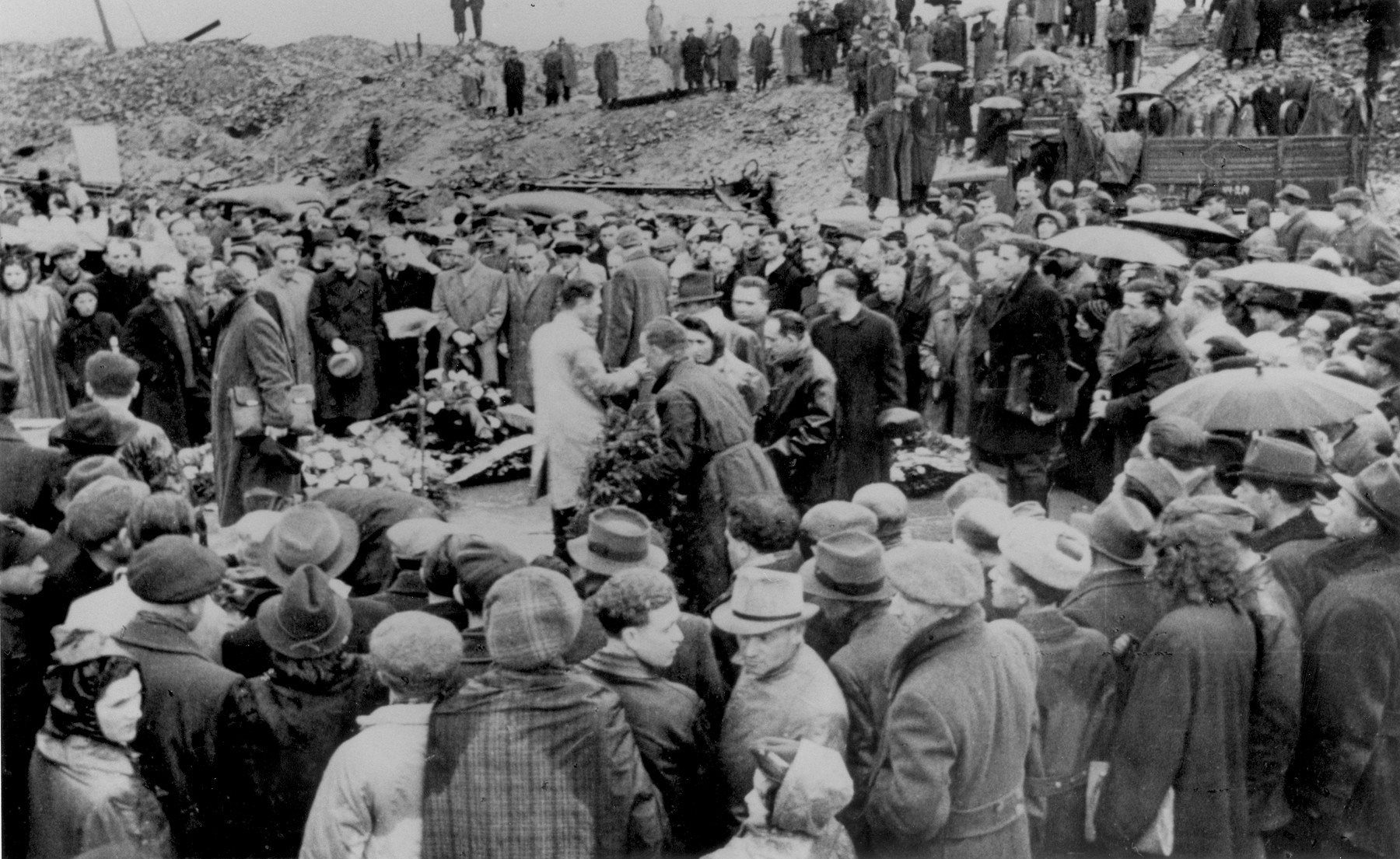 Jewish survivors attend a ceremony in front of the ruins of the former headquarters of the Warsaw ghetto Jewish council [probably to mark the fourth anniversary of the Warsaw ghetto uprising].