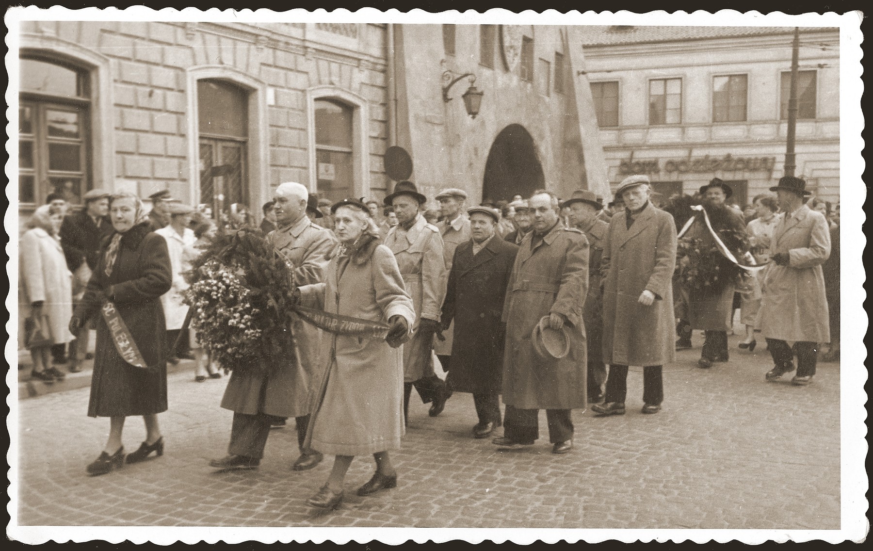 Jewish survivors march through the streets carrying wreaths and ribbons to memorialize the victims of the Holocaust.