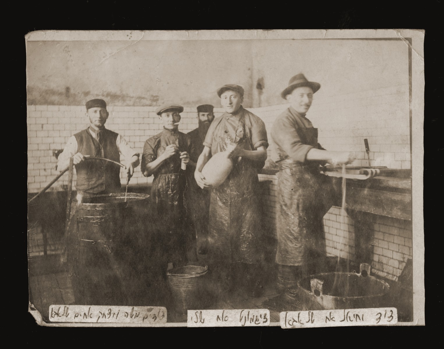 Jewish men at work in a sausage factory in Dabrowa Gornicza, Poland.  

Pictured standing from right to left are: Jechiel Malach, Zishe Malach, Mosze Pinchas and Yitzhak Mordechai Malach.