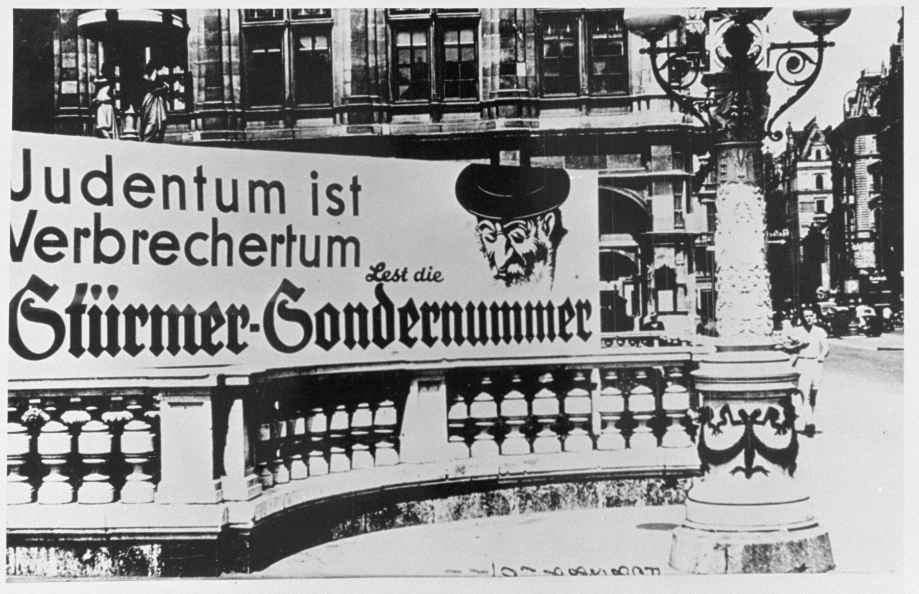 An anti-Semitic "Der Stuermer" advertisement in front of the opera house in Vienna reads: "To be Jewish is to be criminal.  Read the special edition of Der Stuermer."