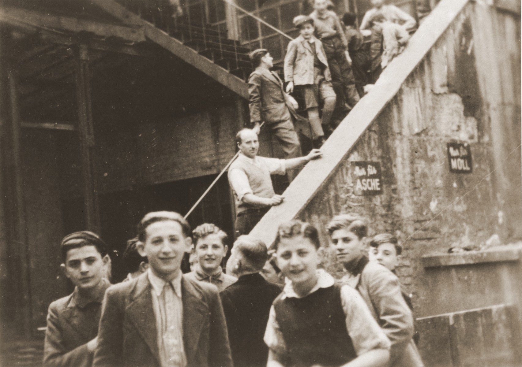 Jewish youth in the courtyard of the Juedische Anlehrnwerkstatt [Jewish vocational training school].

The Juedische Anlehrnwerkstatt was founded in 1936 by the Frankfurt Jewish community to train young Jews expelled from the German public schools.