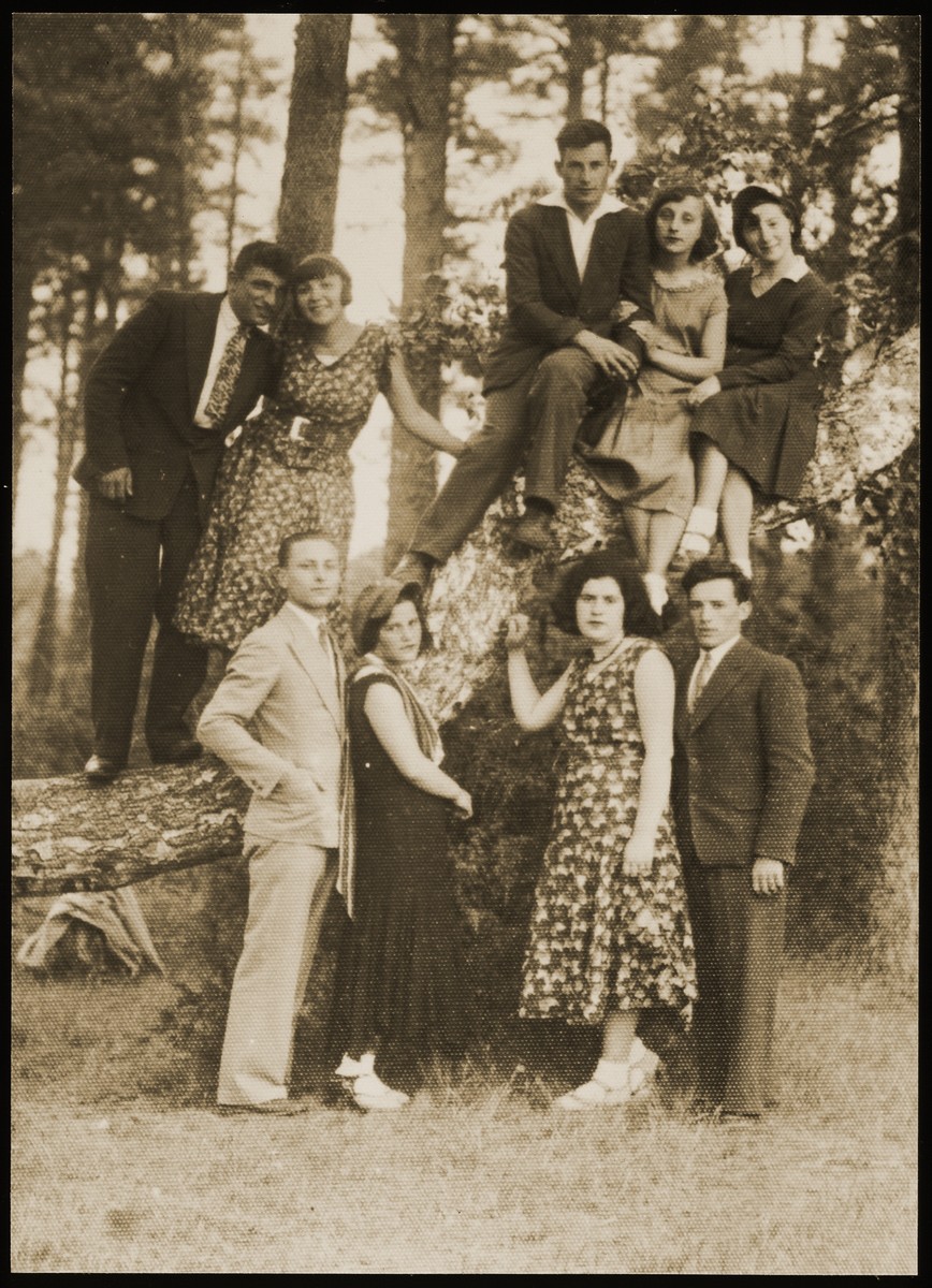 Young couples go for a walk in the Seklutski forest, outside of Eisiskes. 

Among the friends are Szeina Blacharowizc (seated on the branch, right) ; Malka Matikanski with her boy-friend Zahavi (standing on the branch, second from left) ; Miriam Koppelman (standing first row, second from right).