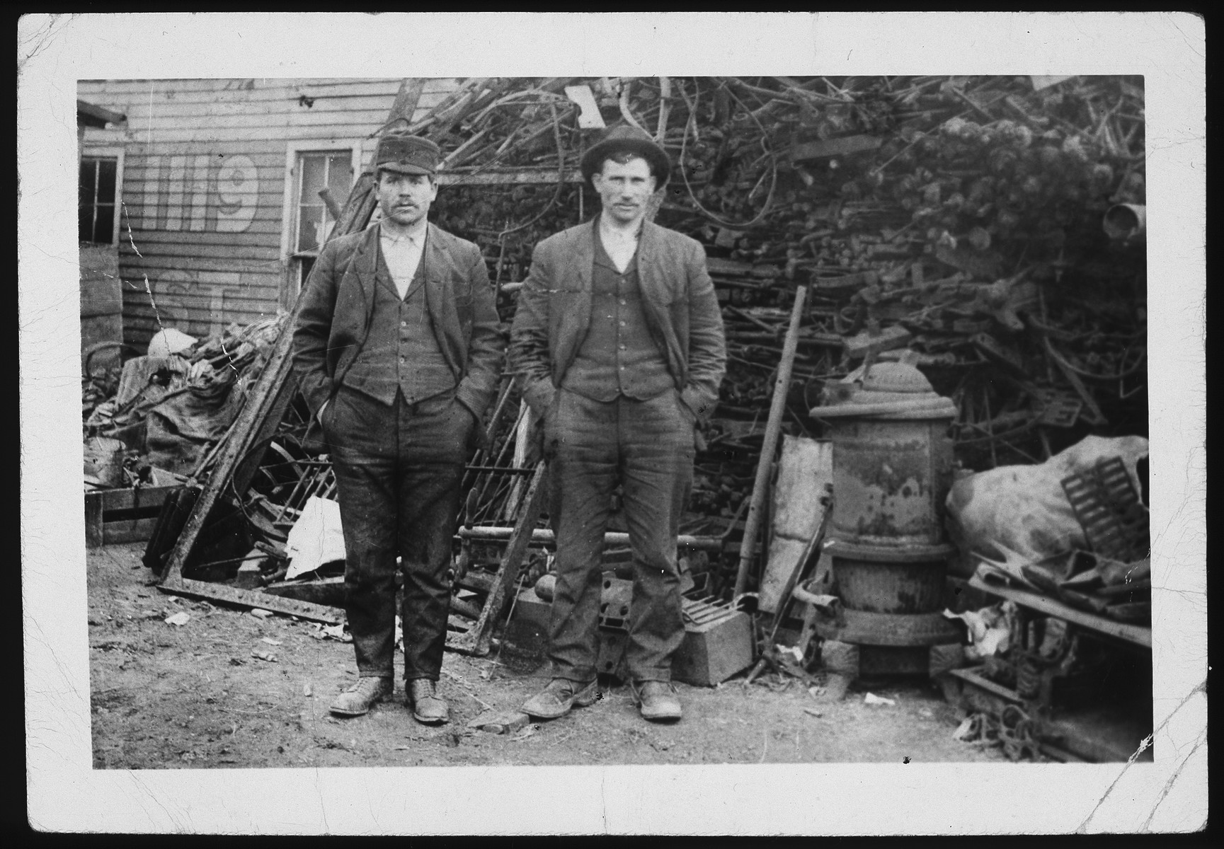 Morris (right) and Yitzhak Asner stand in front of a pile of scrap metal.