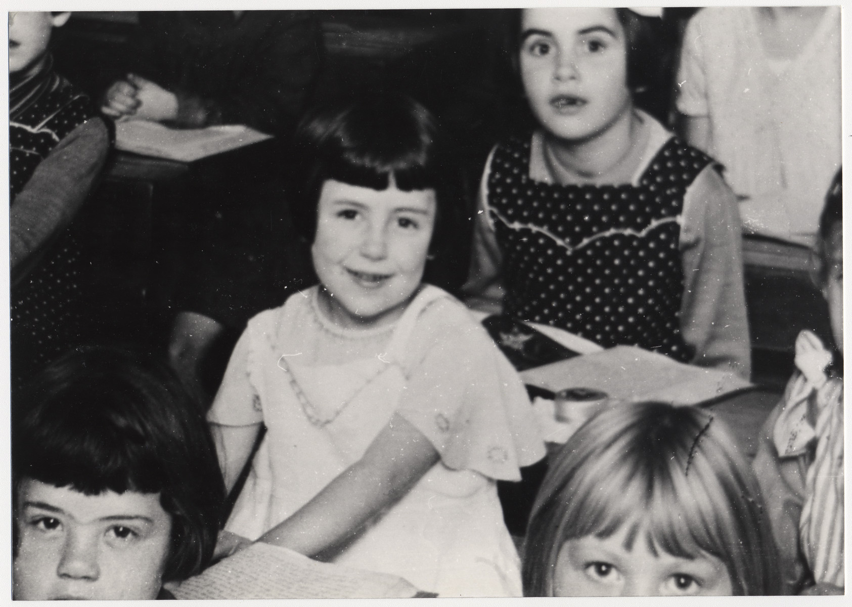 Close up of a several young students at their desks.

Among those pictured (center, in white) is Ilse Kahn , a cousin of the donor (Kurt Pauly).