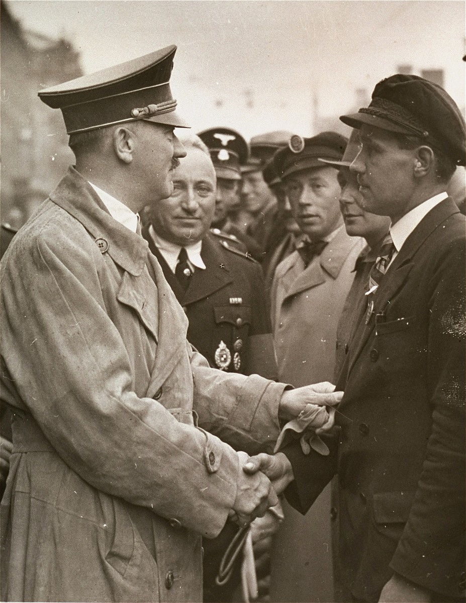 Adolf Hitler greets an autobahn worker at a Reichsparteitag (Reich Party Day) rally in Nuremberg.

Pictured second from the left is Robert Ley.
