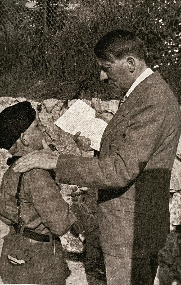 A "wolf-cub" or junior member of the Hitler Youth hands Hitler a letter written by the child's sick mother.