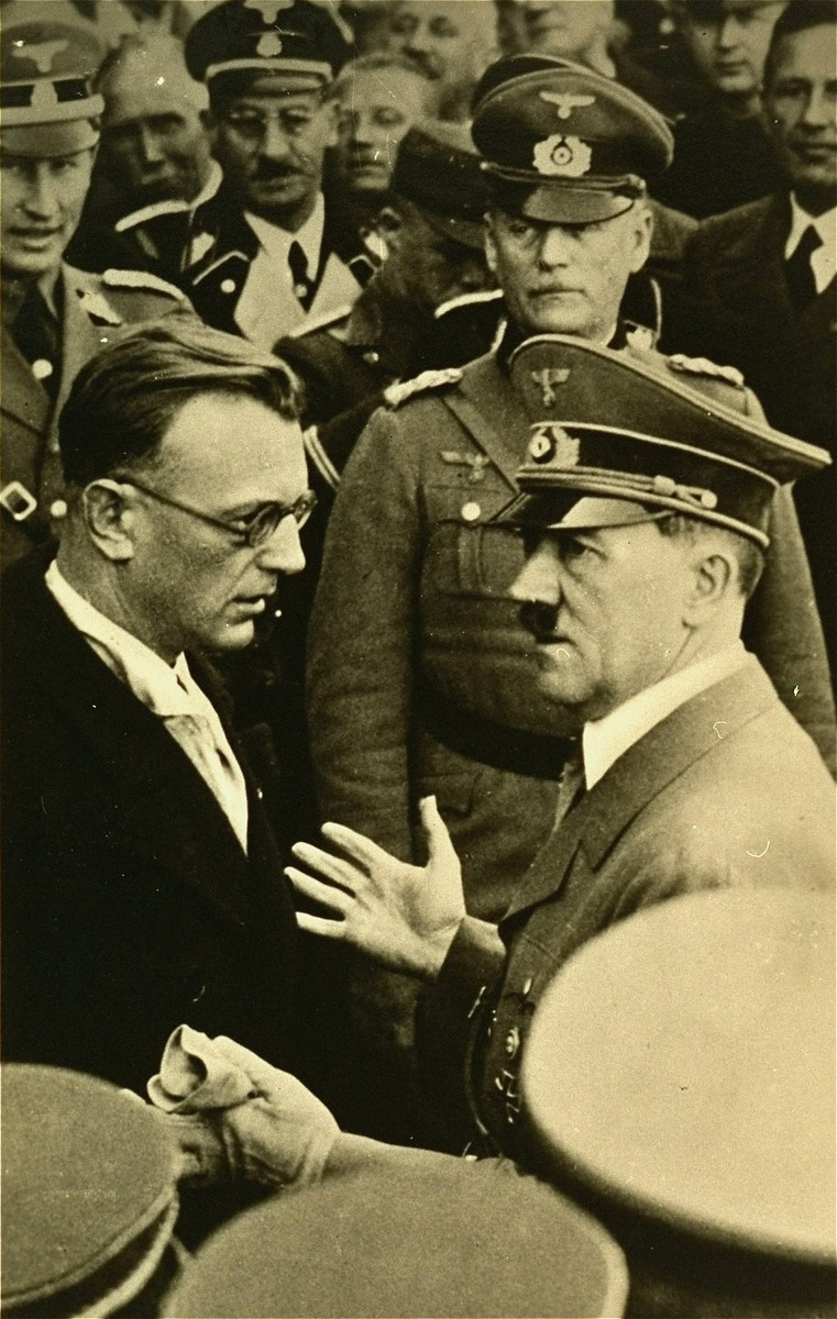 Hitler in conversation with Artur Seyss-Inquart (left) at an official ceremony.  Reinhard Heydrich stands behind Inquart (left), and General Wilhelm Keitel stands behind Hitler.