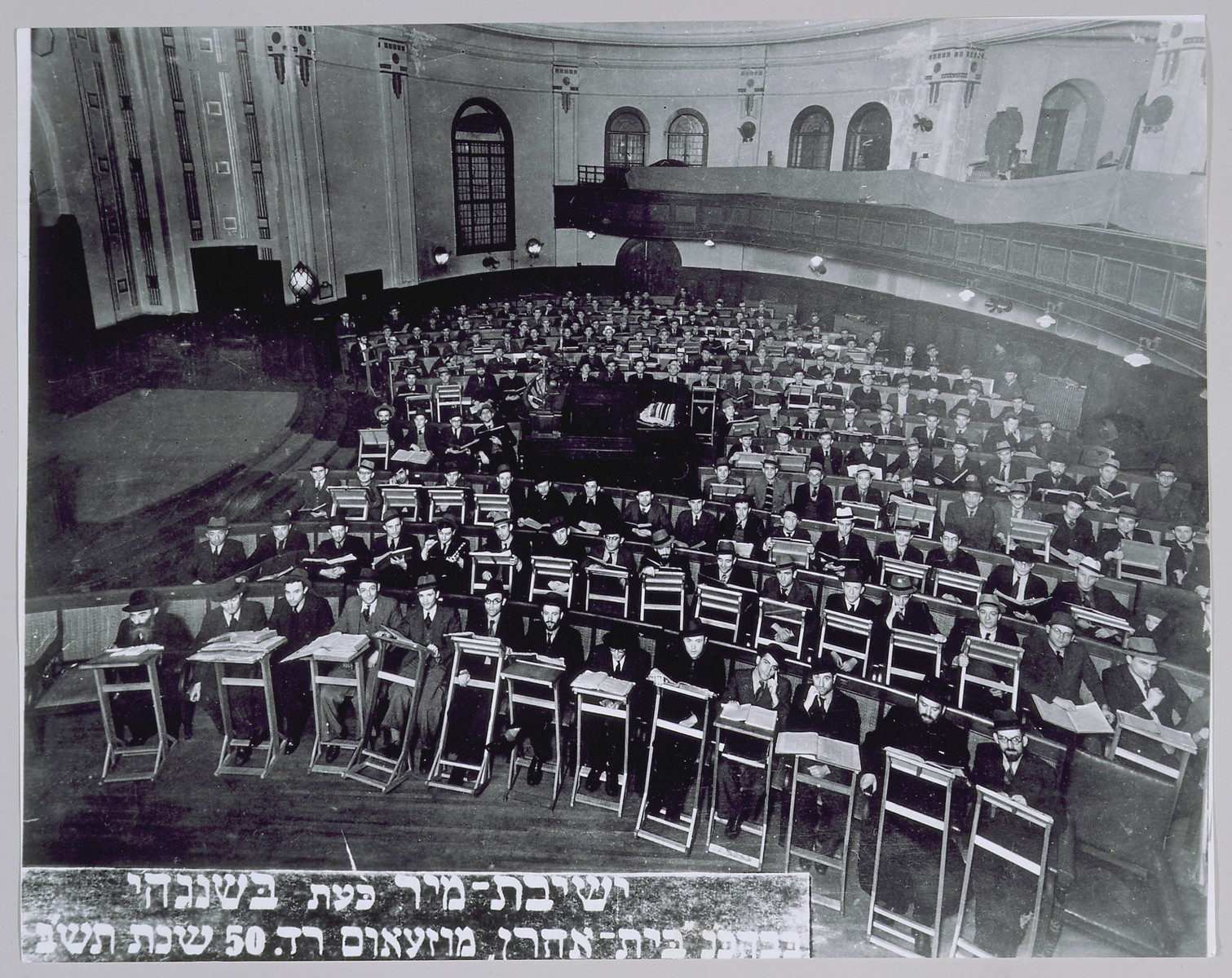 Students and teachers of the exiled Mir yeshiva study in the sanctuary of the Beth Aharon synagogue on Museum Road in Shanghai.

Among those pictured are: Rabbi Chezkel Lewensztejn (front row, first from the left); Rabbi Chaim L. Szmuelowicz, acting dean (front row, second from the right); and Rabbi J.D. Epstein, secretary (front row, first from the right).