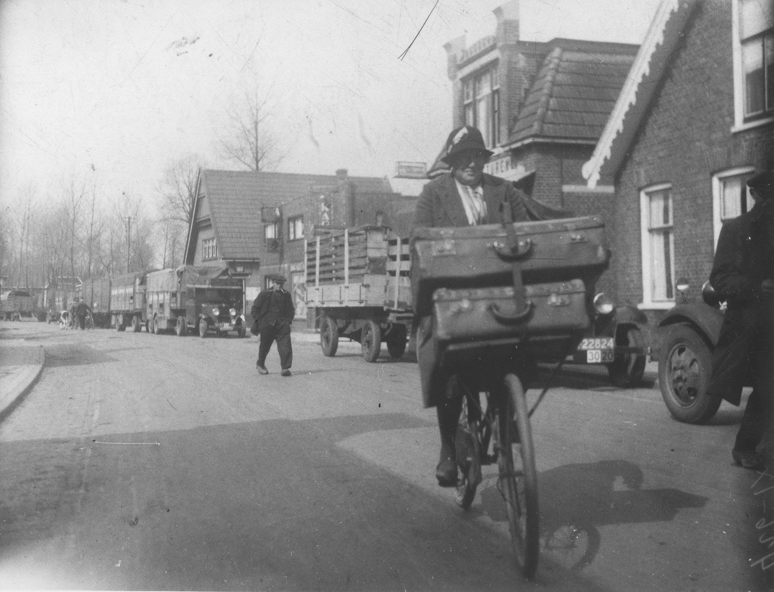 Betje Wijnberg rides a bicycle with two large suitcases.  The suitcases are filled with sewing notions that she is peddling to local farmers.

Betje Wijnberg (b. August 28, 1886) is the aunt of Selma Wijnberg.  She was deported to her death in Auschwitz on September 17, 1943.
