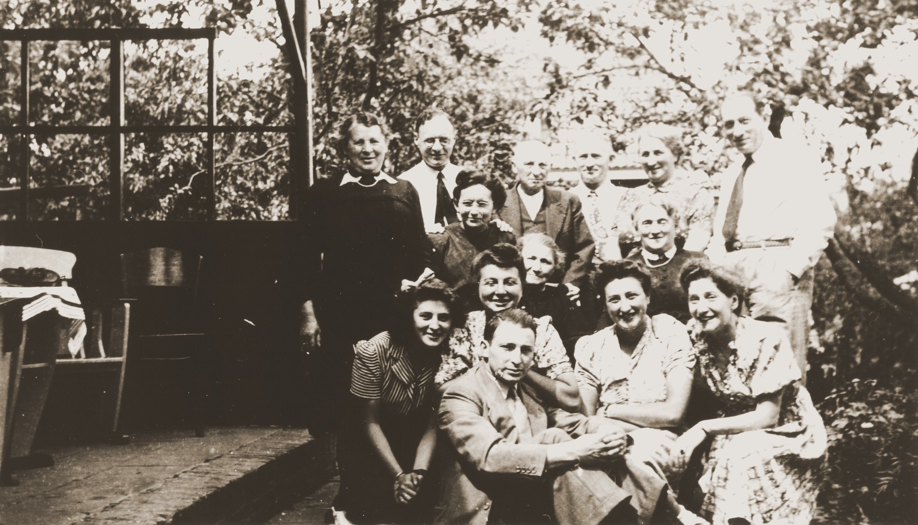 Group portrait of the extended Meijer family at the home of Hennie Meijer in Boekelo.

Pictured standing in the back row, from left to right are:  Na Meijer Berg, Albert Laufer, Joseph Meijer, Johny Meijer, Hennie Meijer, and Willem Meijer.  Seated in the third row from the front are Nannie Laufer (in front of Albert), unknown, and Lina Neuman Meijer (in front of Hennie).  Seated in the second row from left to right are: Sarie Berg, Renee (Sara) Meyer, Bep Meijer, and Gerta Sajet.  Seated in front is Richard Meijer.