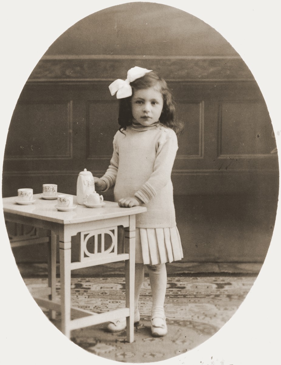 Studio portrait of Johanna Meijer playing with a tea set.  

She perished along with her three siblings during the Holocaust.