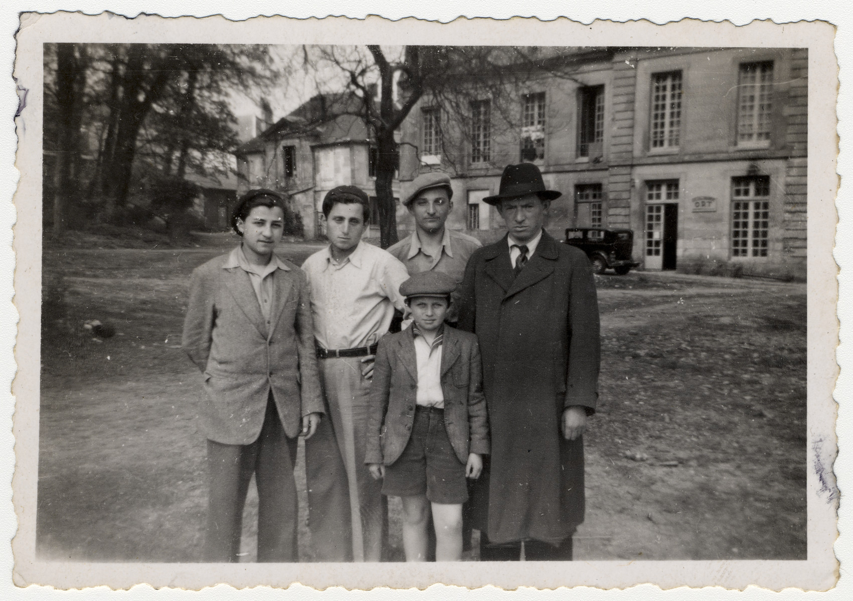 A group of teenagers stand with a child and man outside a home in Saint Pierre de Chartreuse.