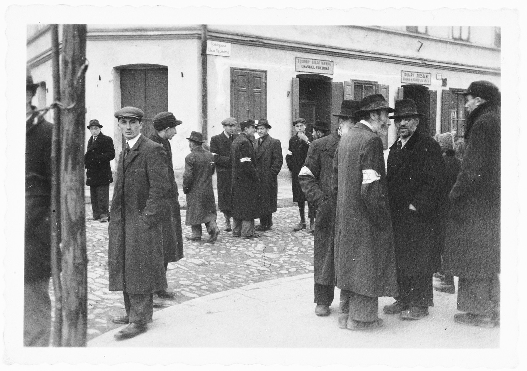 Polish Jews stand on a street corner of the [possibly Nowy Sacz] ghetto.