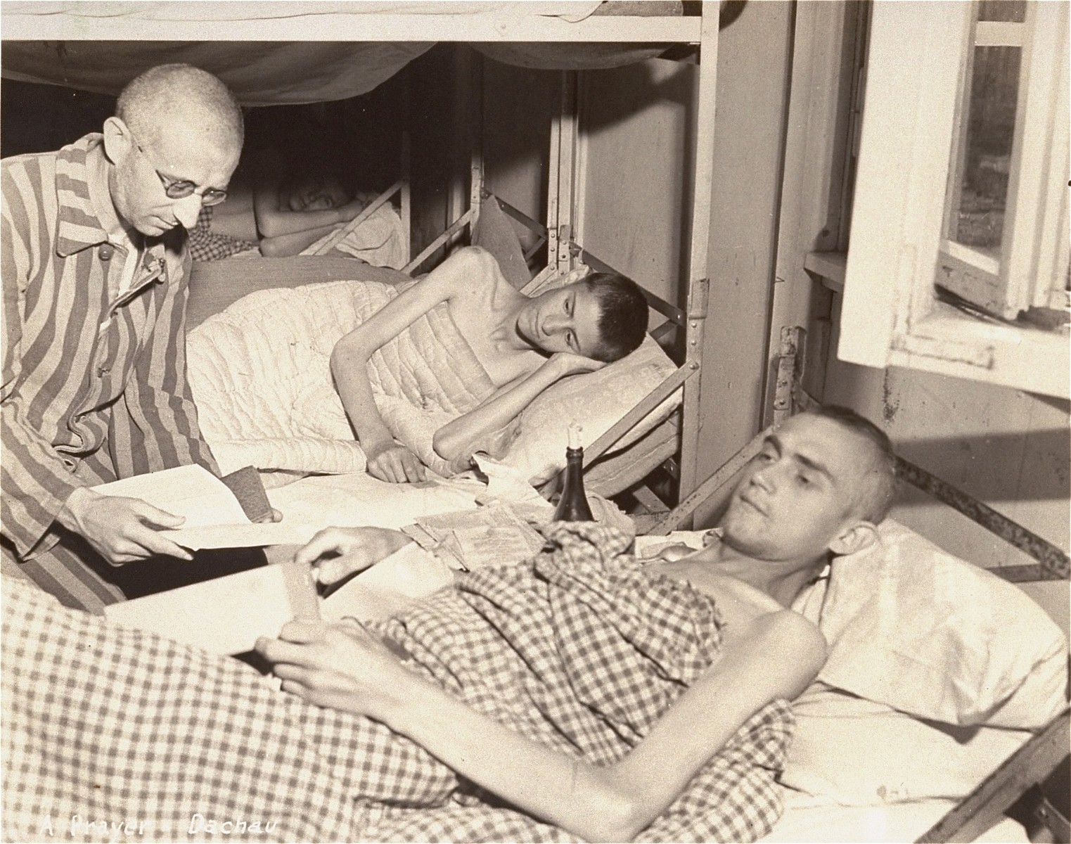 Survivors praying in the camp infirmary after liberation