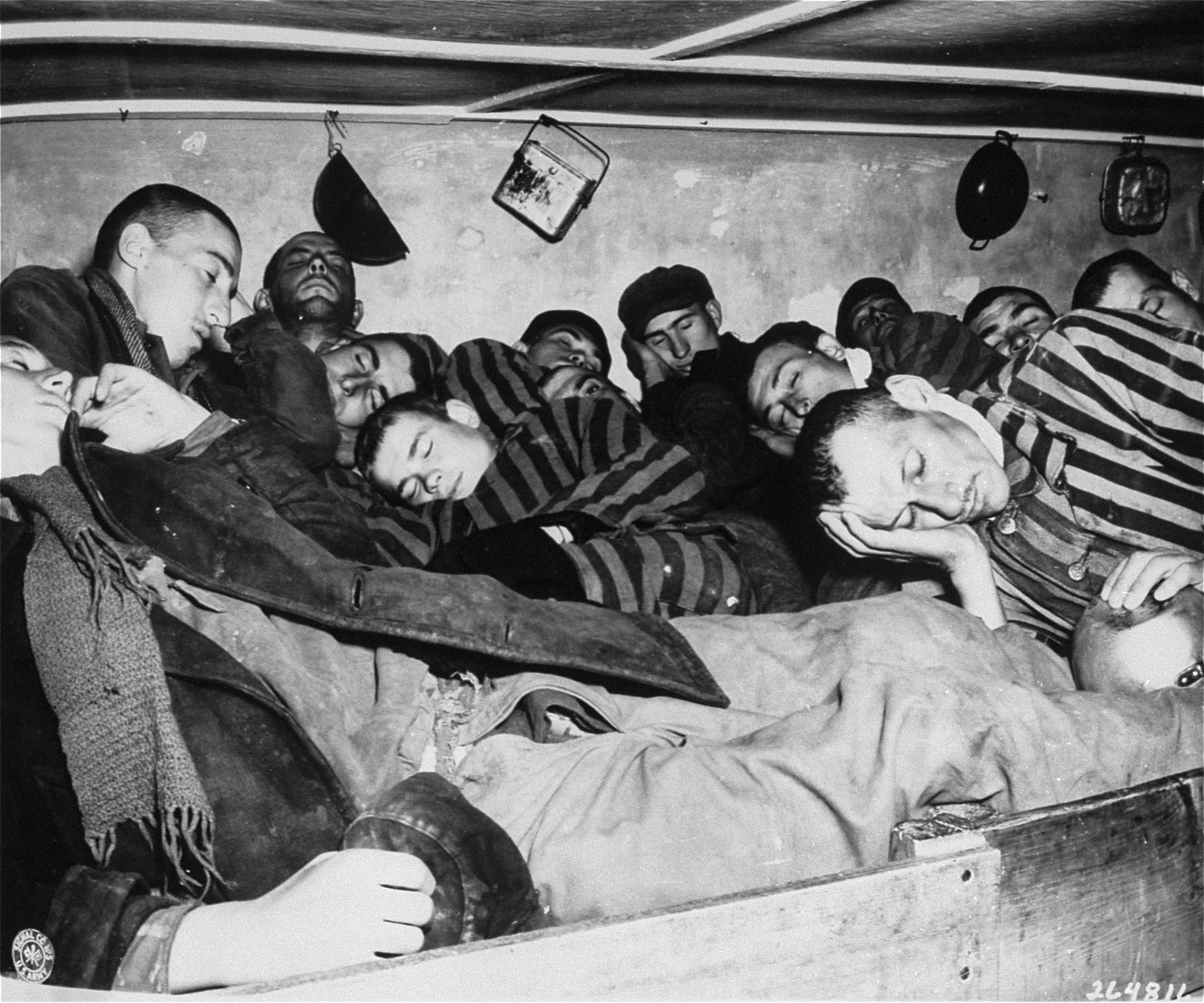 Survivors in Dachau packed into overcrowded sleeping quarters, where 7 men  had to share 2 small