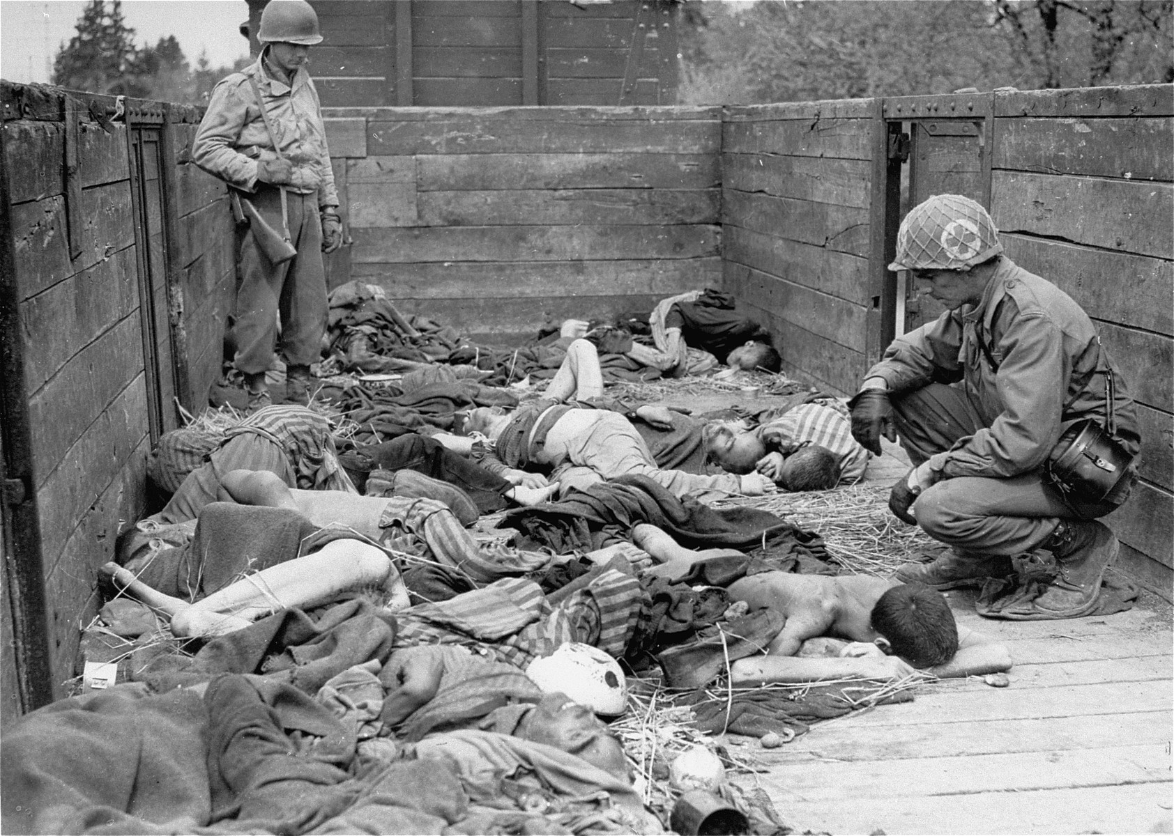 Medical corpsmen of the Seventh US Army view the bodies in one of the open railcars of the Dachau death train.

The soldier standing in the rear of the car is Kenneth Dean Johnston.