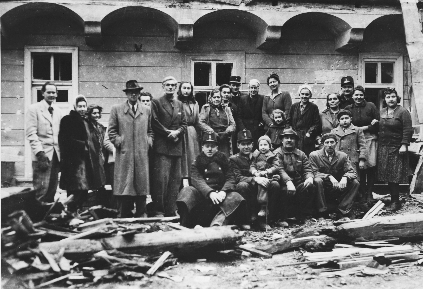 Charles (Carl) and Gertrud Lutz pose with police and former employees among the ruins of the British legation in Budapest after the liberation.

Among those pictured is Carl Lutz, his first wife, Gertrud, his future wife, Magda, and his future step-daughter, Agnes.