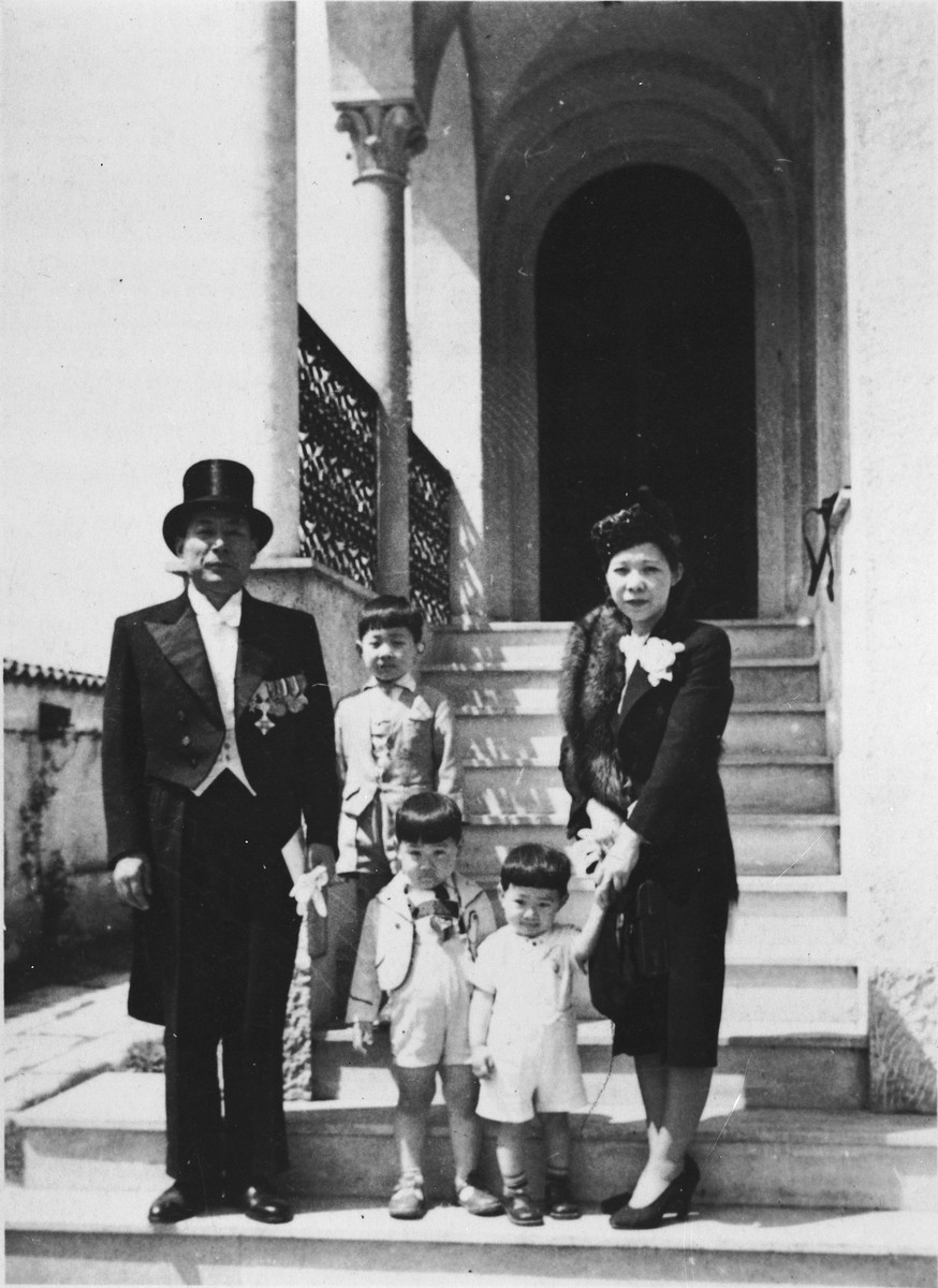 Chiune Sugihara in full diplomatic regalia, poses with his family outside their residence.