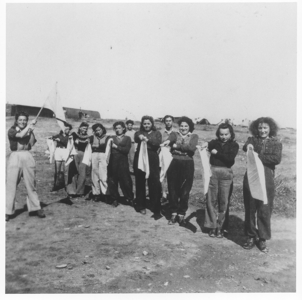 Young Jewish women who have been interned in a detention camp on Cyprus, are instructed in the use signal flags as part of their paramilitary training.

Among those pictured is Pnina Halpern (at the far right).