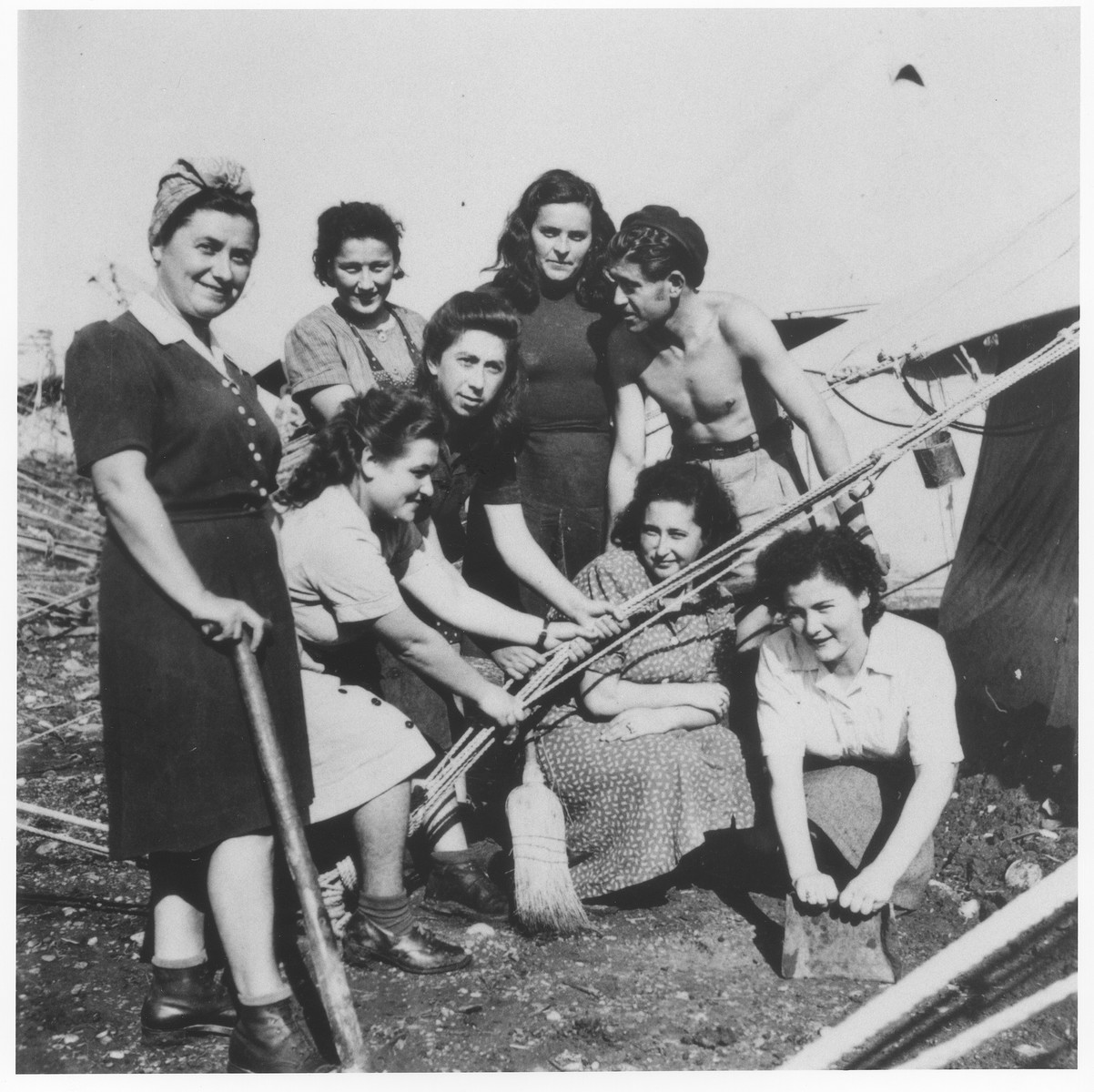 A group of young Jewish DPs pitch a tent in one of the detention camps on Cyprus.

Pictured from left to right are Malka ?, Pnina Halpern, Henchi Hellman, Rachel ?, Malka Hus, Richie Strasser and Leah Halpern.