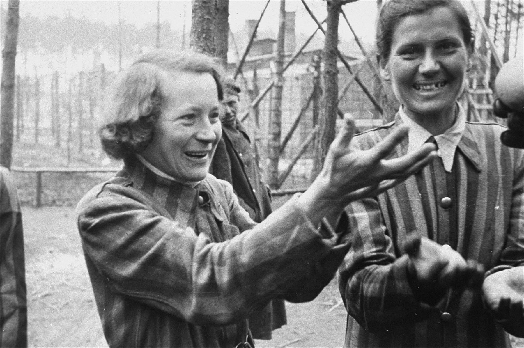 Women survivors in the Woebbelin concentration camp reach for oranges handed to them by American soldiers.