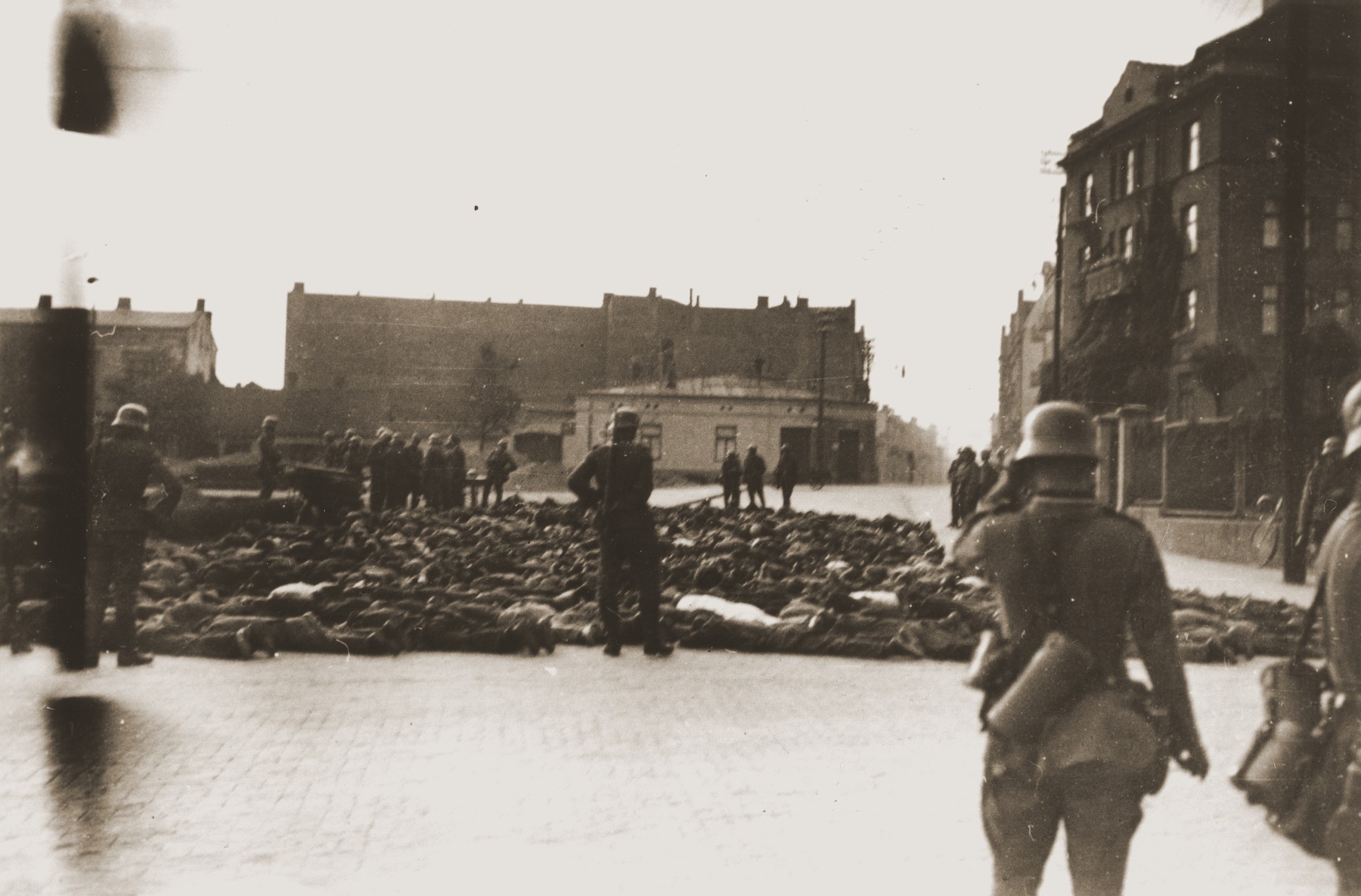 German soldiers patrol a public square in Czestochowa, where the bodies of those they shot have been collected.

One photograph from an album belonging to a member of a Wehrmacht machine gunners' unit, which was found after the war by Lorenzo Hawkins (the donor's grandfather), an American serviceman in Company B, 56th Armored Engineer Battalion.