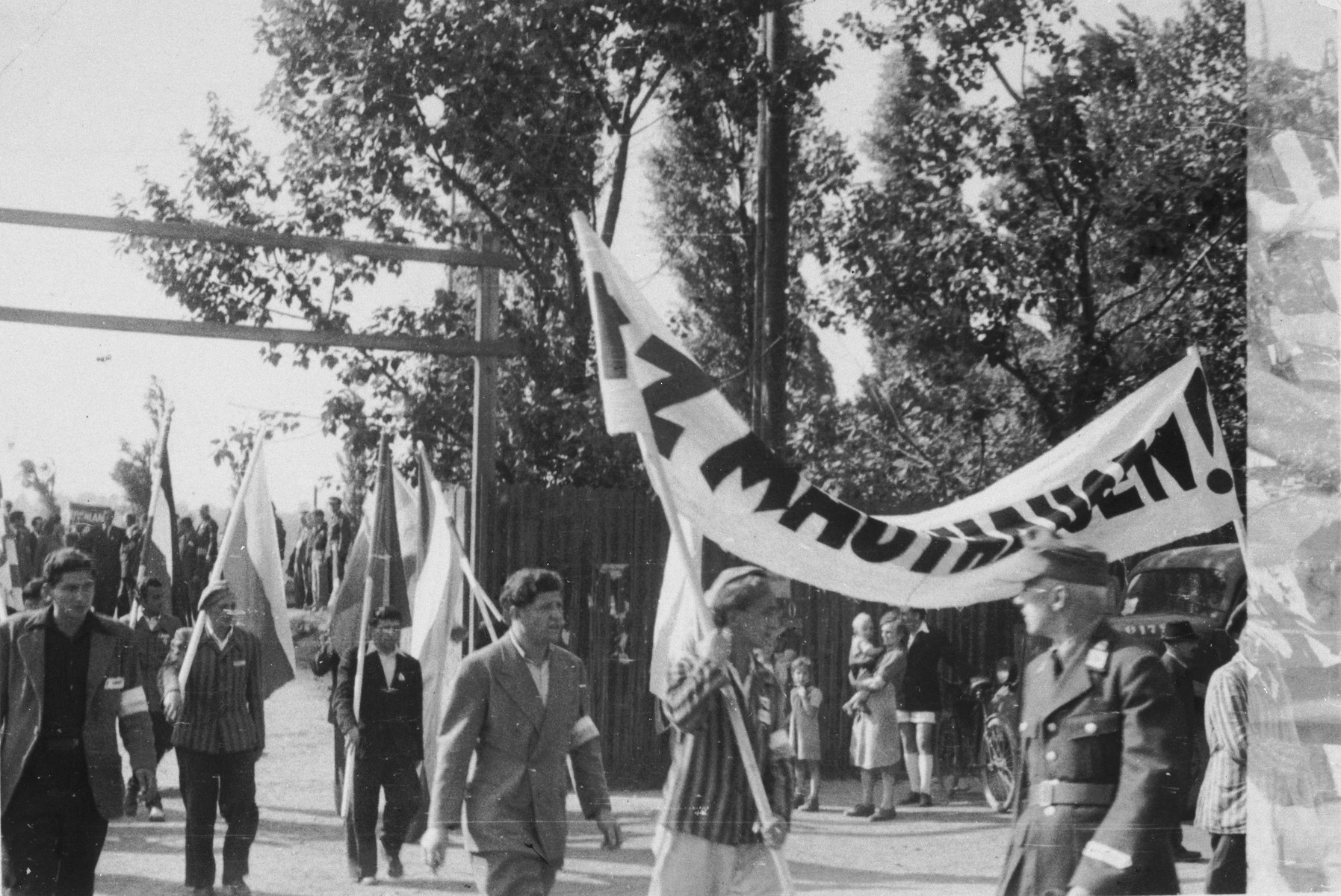 Jewish DPs march with banners and flags in the Bindermichl displaced persons camp to commemorate the Jewish victims of the Mauthausen concentration camp.