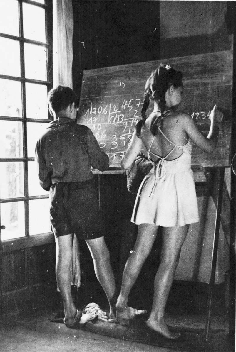 Two children write equations on the blackboard during a mathematics lesson at in the Mehoncourt children's home.