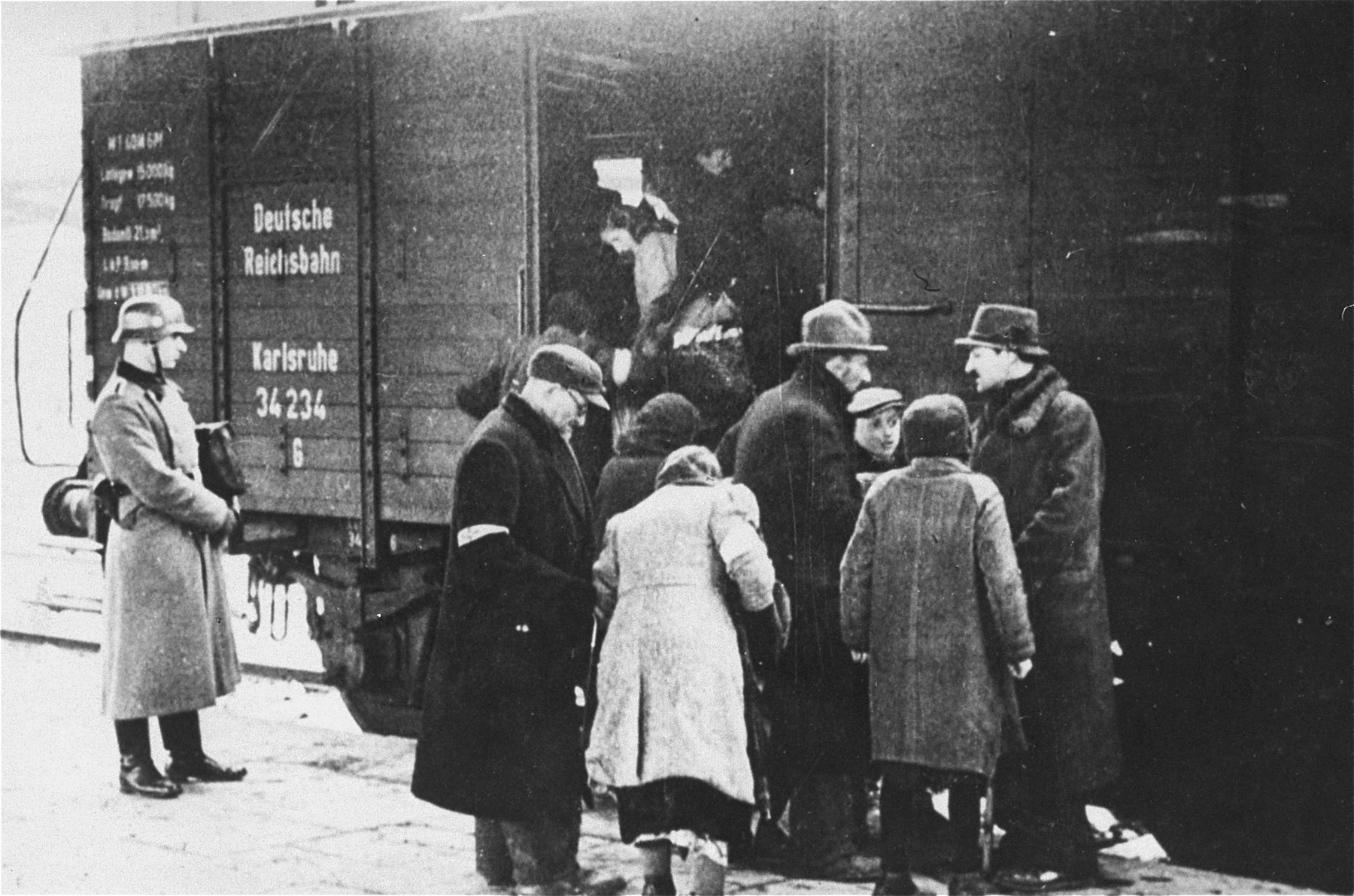 A member of the German SS supervises the boarding of Jews onto trains during a deportation action in the Krakow ghetto.