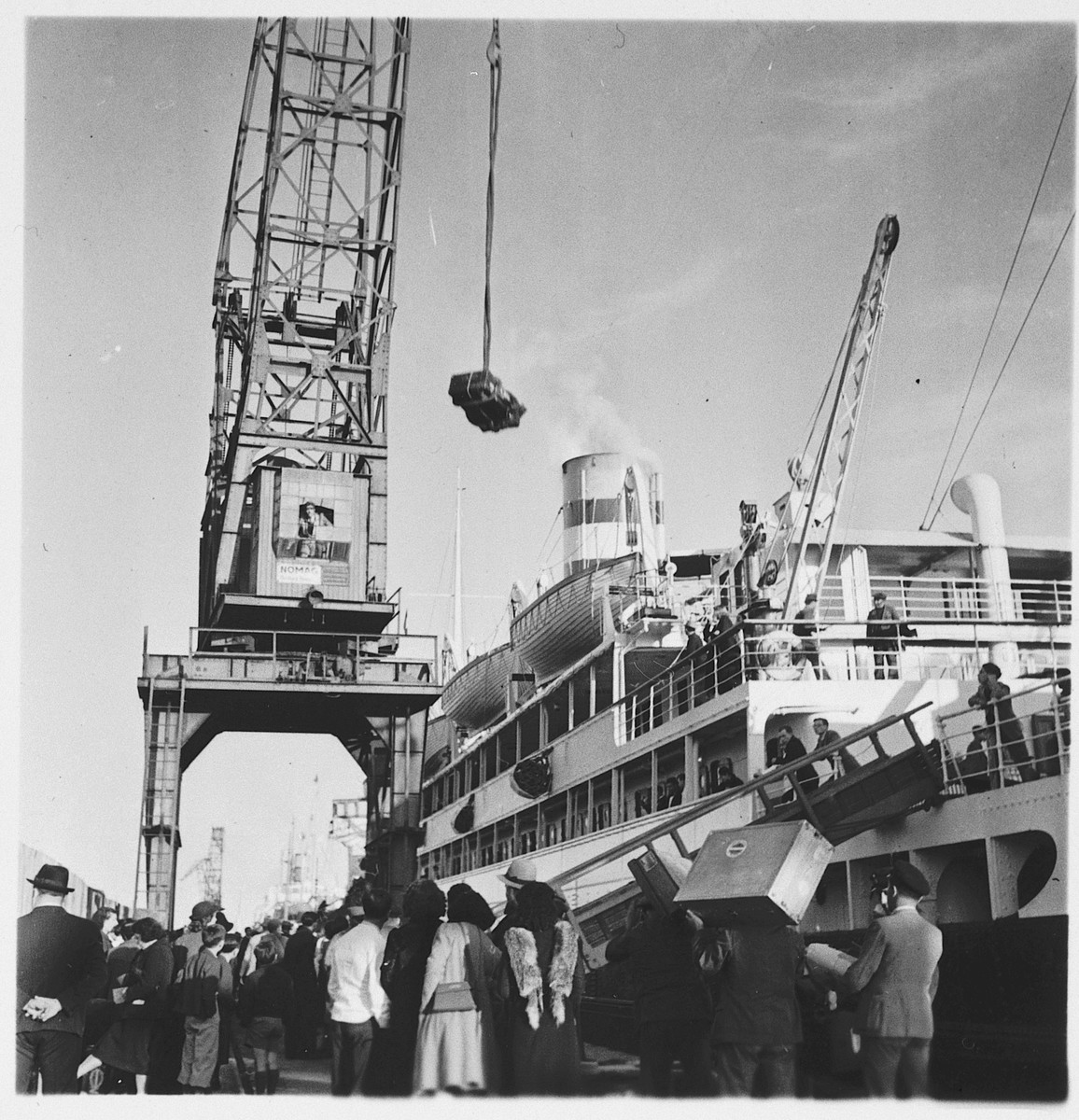 Jewish refugees watch as a crane is used to load their luggage onto the SS Serpa Pinto in the port of Lisbon.