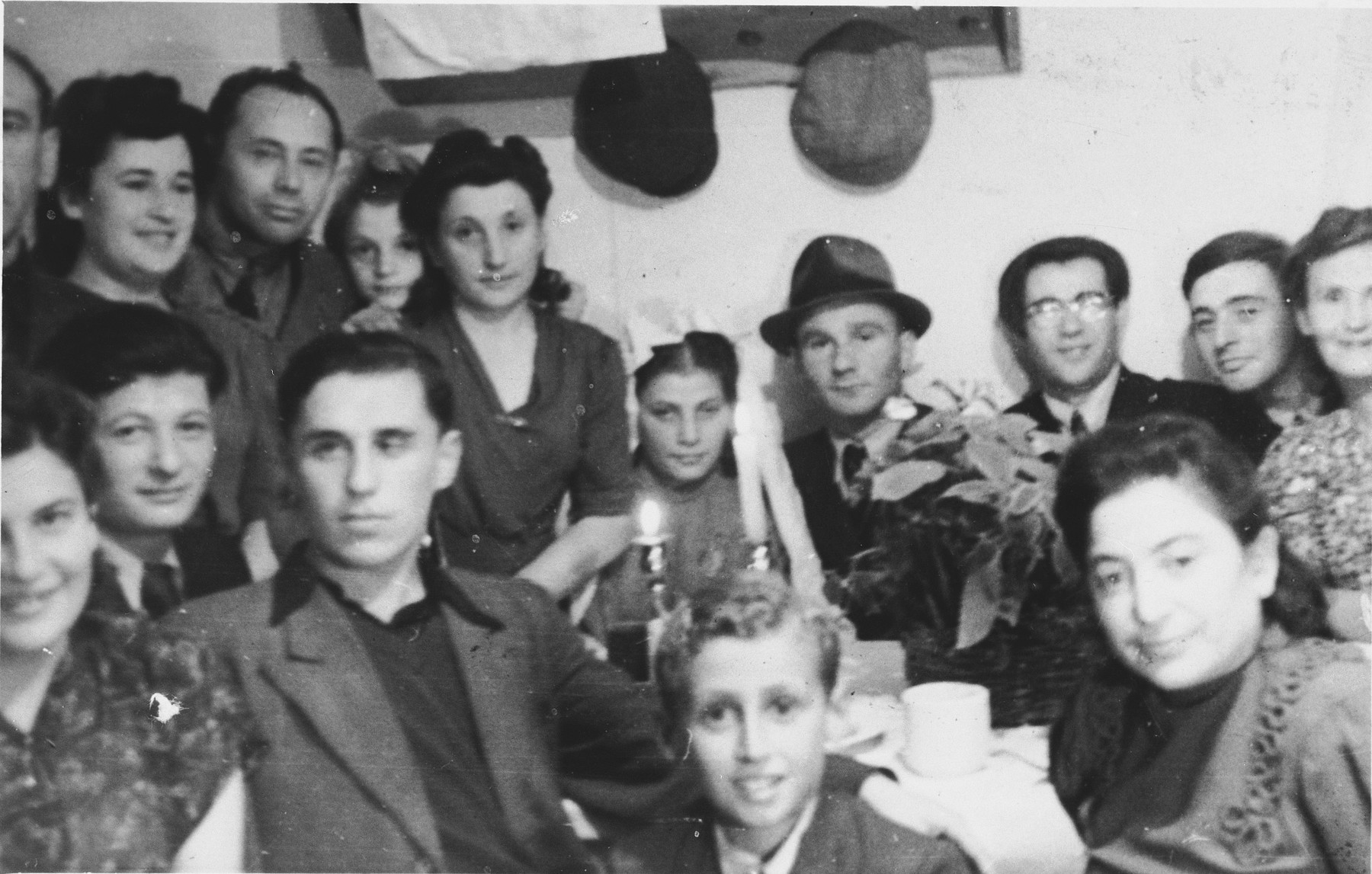 A wedding party gathers around a table with two candles in the Schlachtensee displaced persons camp.

The inscription on the back reads, "Ilub Piemiazek/I Liberman."