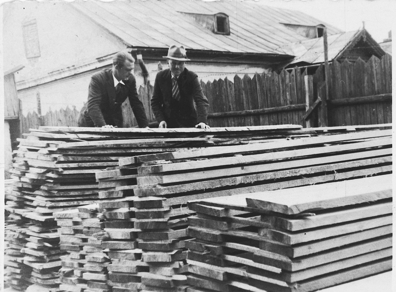 A Jewish lumber merchant talks to a customer in the family lumberyard in Rzeszow, Poland. 

Among those pictured is Aron Jam (right).