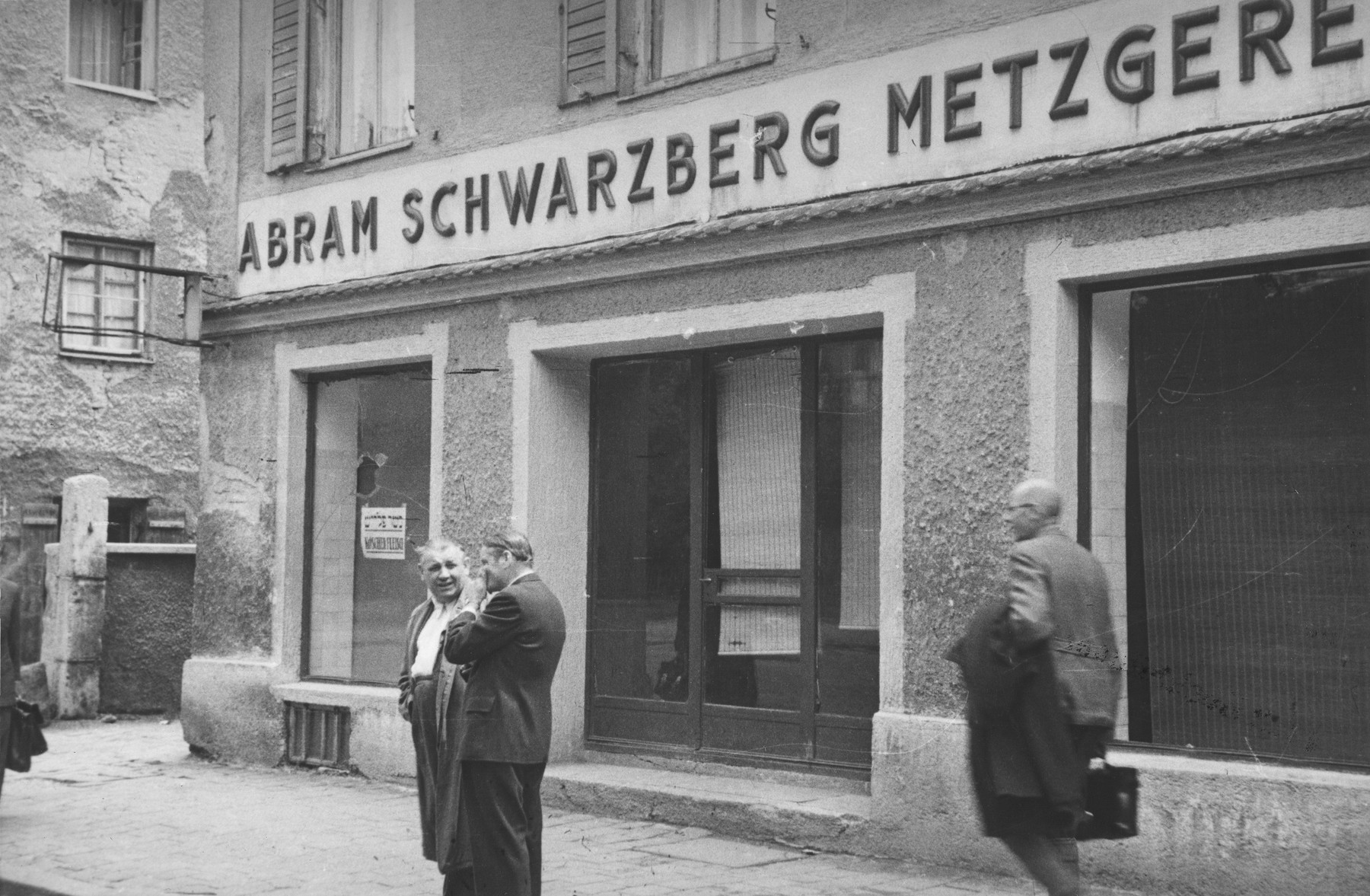 Two men stand outside a kosher butcher shop on the Ismaningerstrasse in Munich that was vandalized in an anti-Semitic attack.